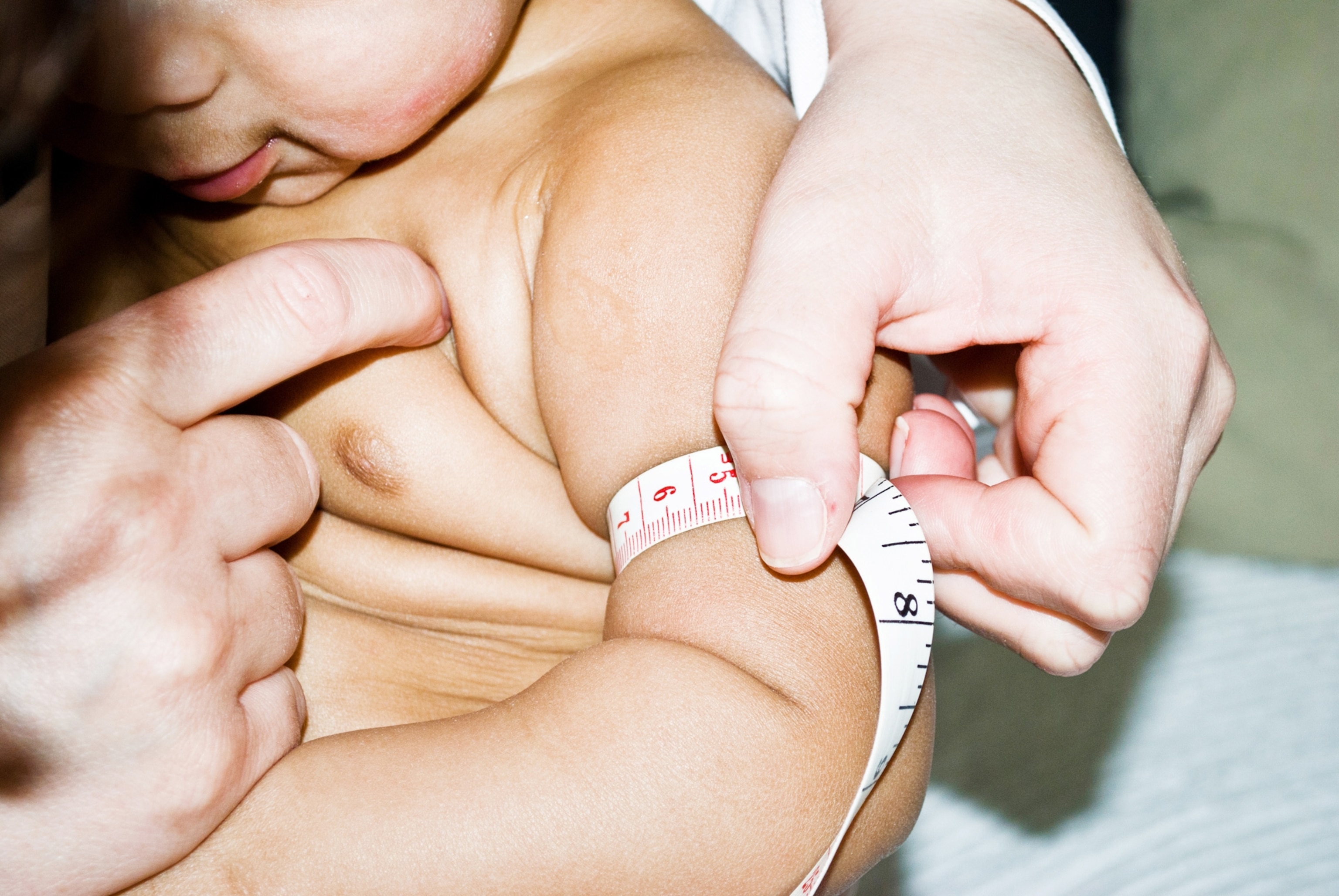 Photo of toddler with measuring tape around arm