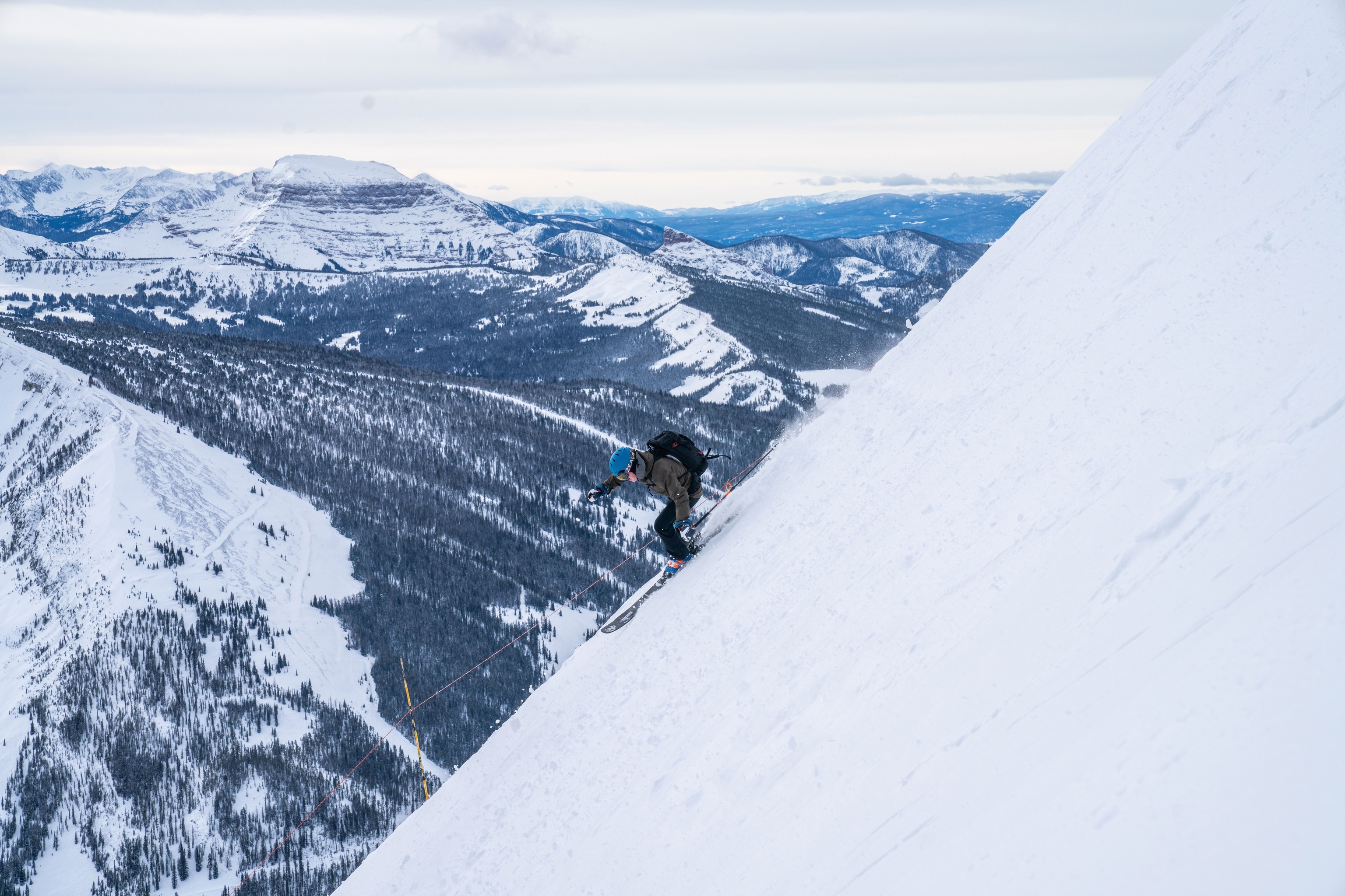 skier rushing down steep mountain