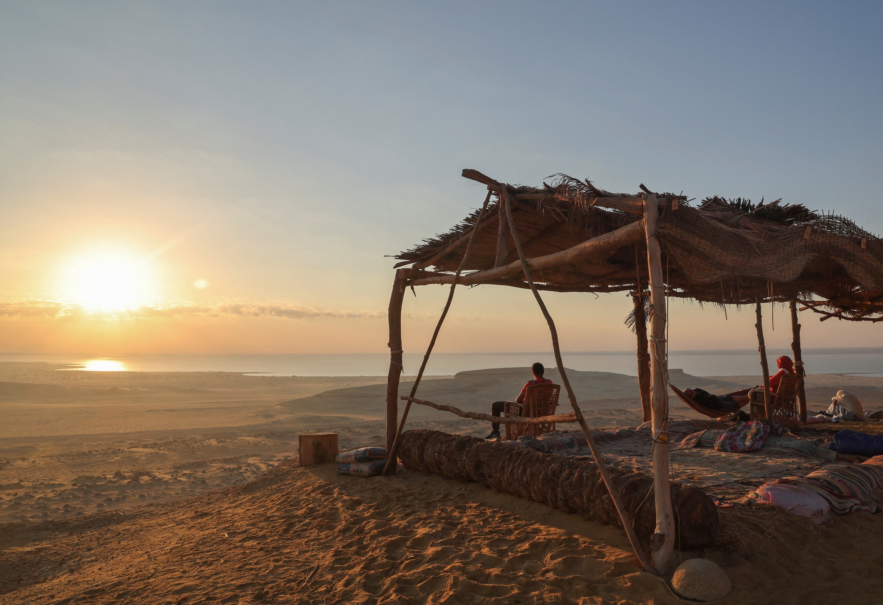 People watch sunrise on Qatrani camp next to Lake Qarun Protectorate in Fayoum, Egypt