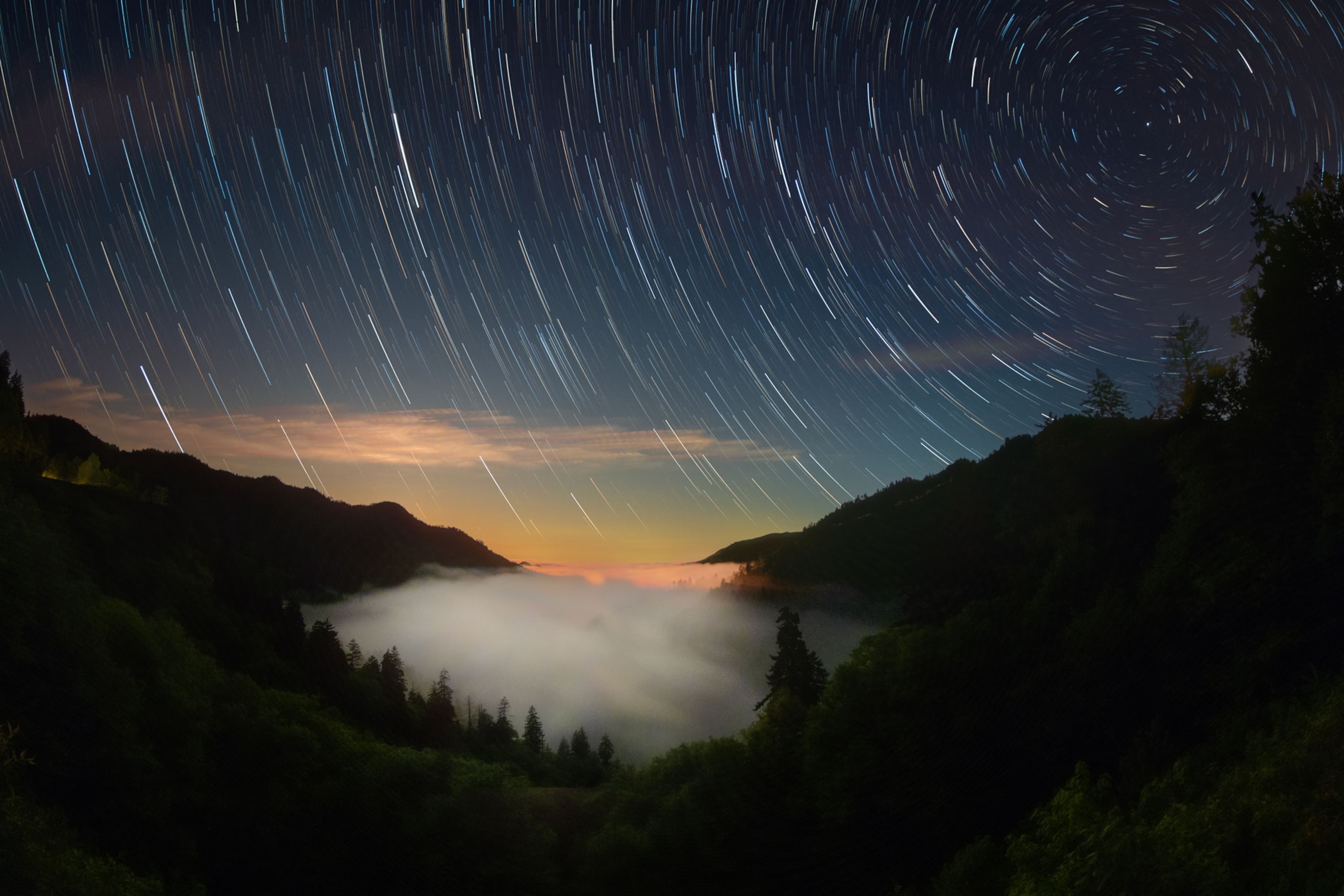 A long exposure image reveals star trails over the Great Smoky Mountains