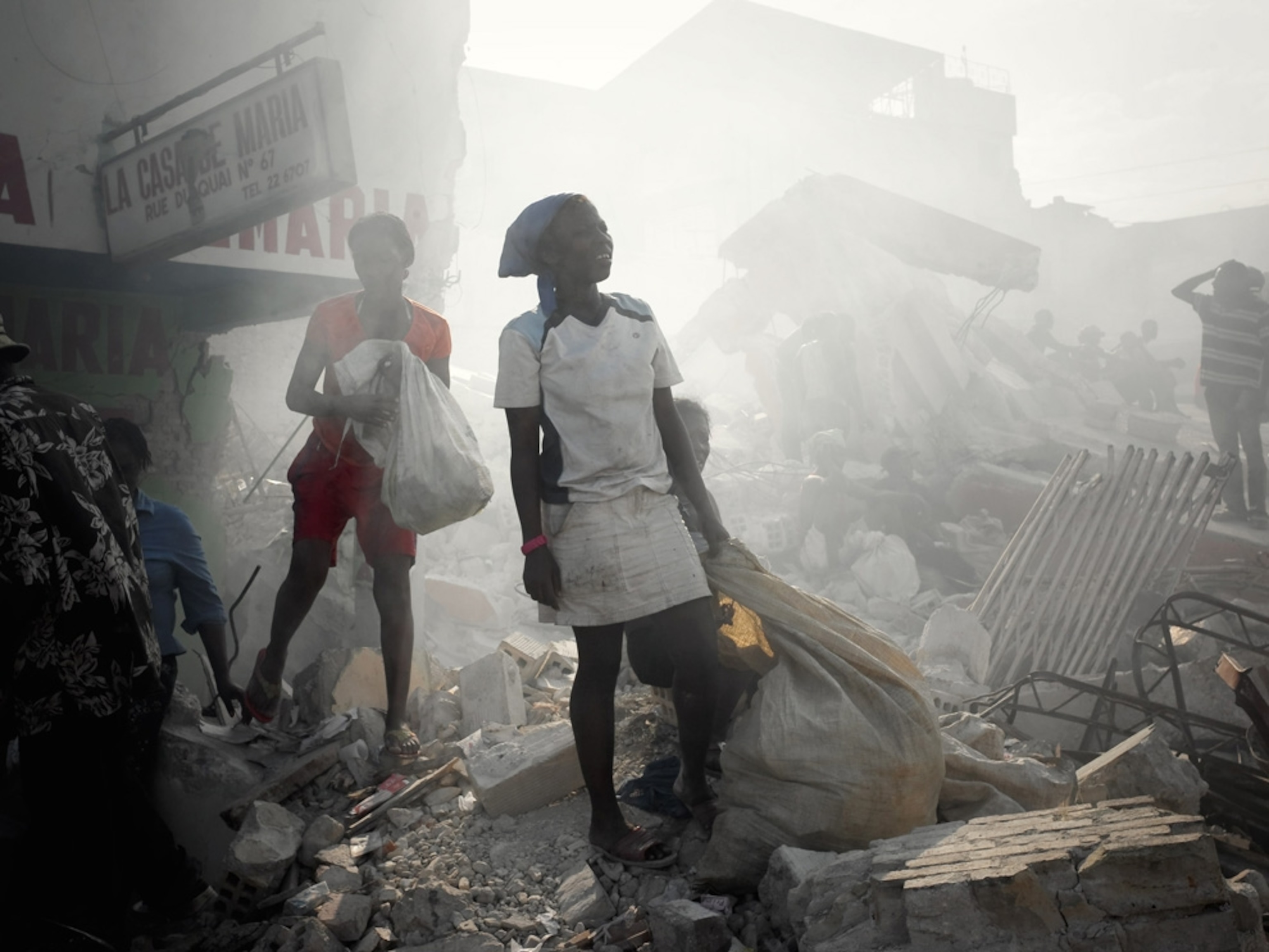 Two Haitians walk through the rubble-filled streets after the Port-au-Prince earthquake.