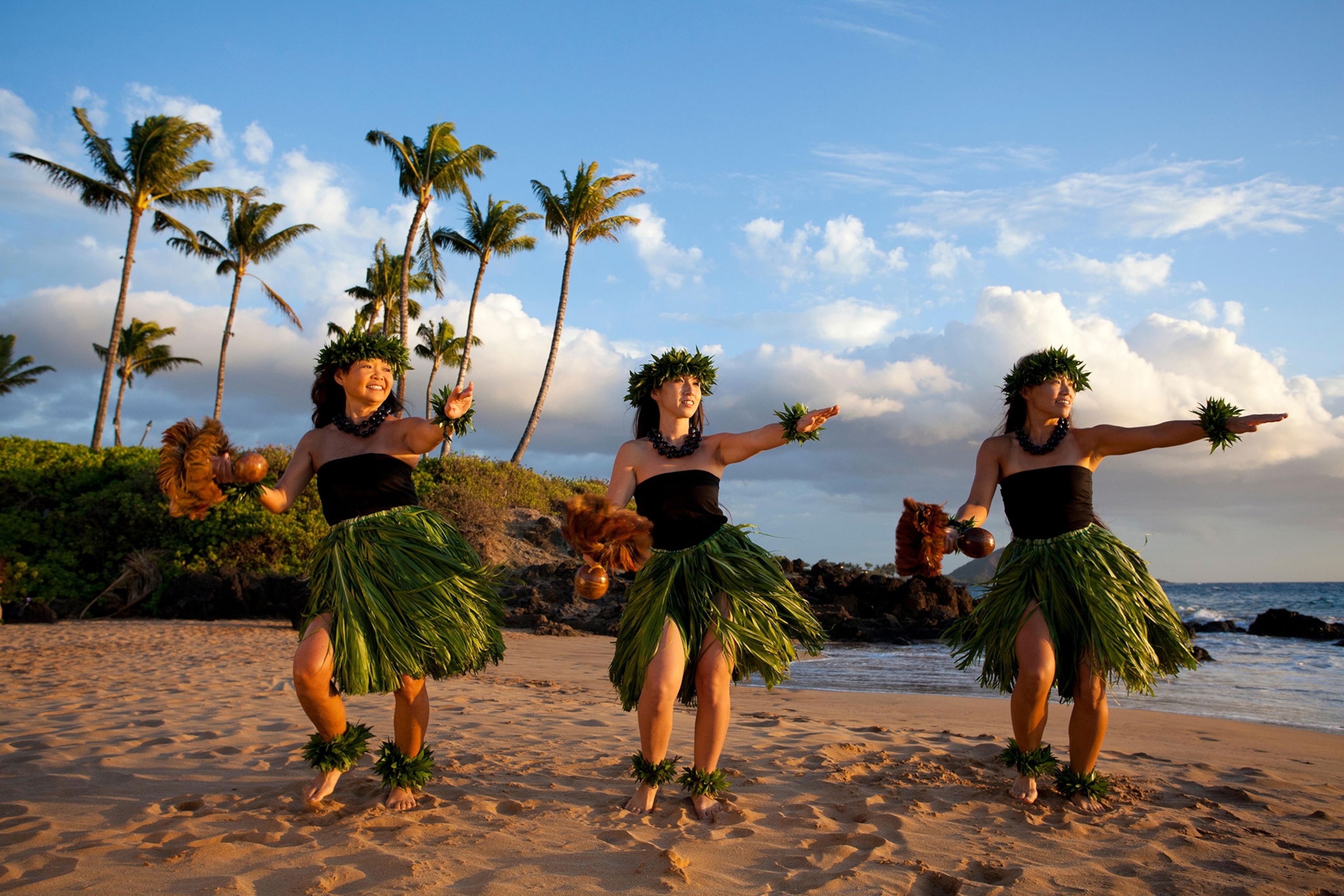 three hula dancers on the beach