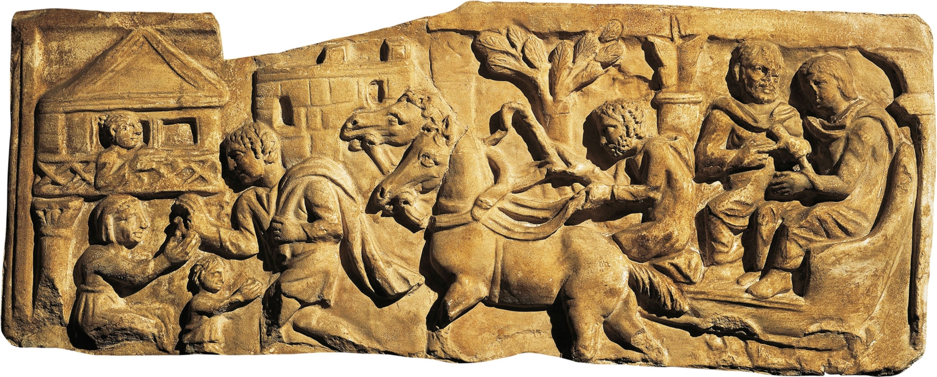 A stone relief of men and horses at a house