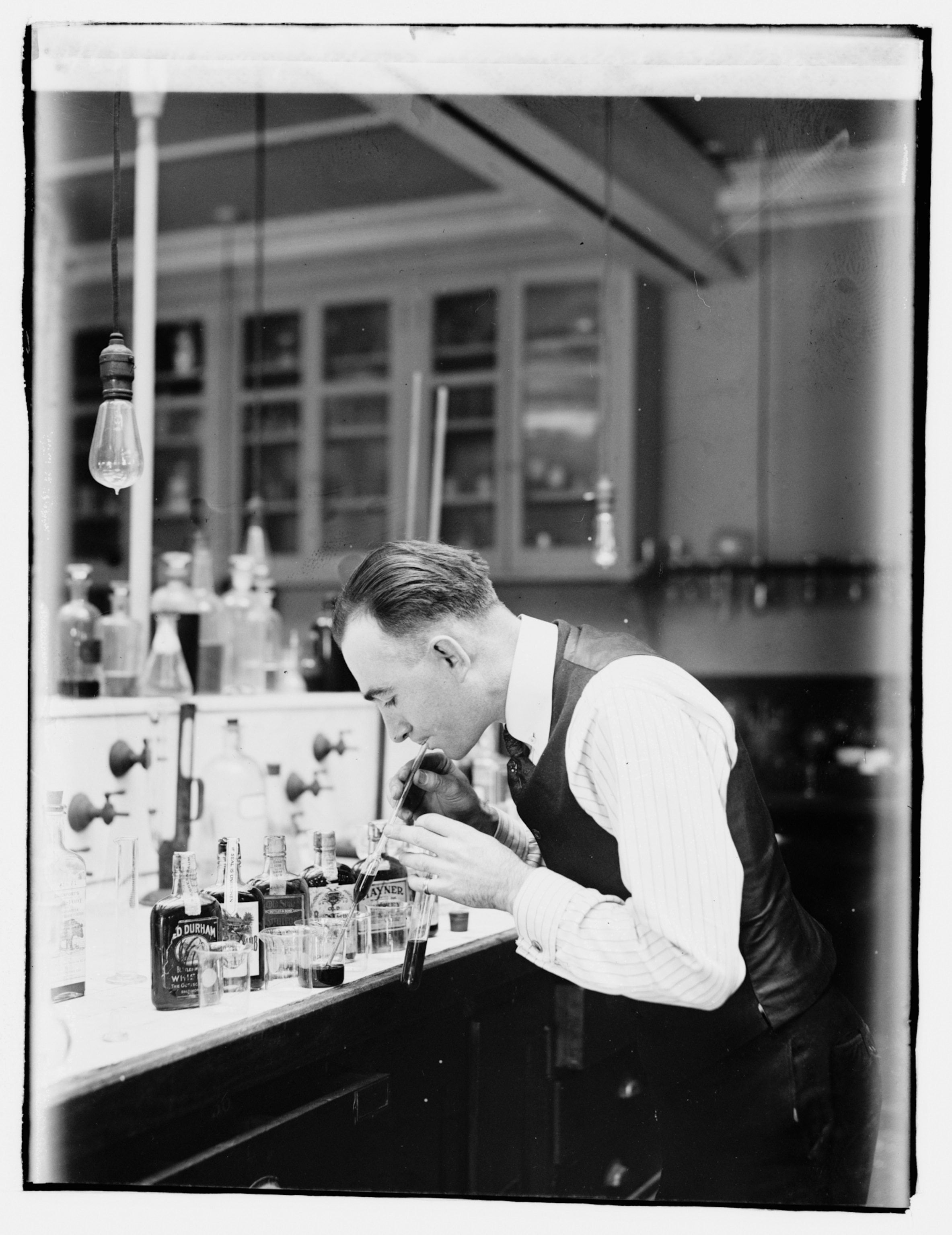 A man in a white shirt hunched over a table working.