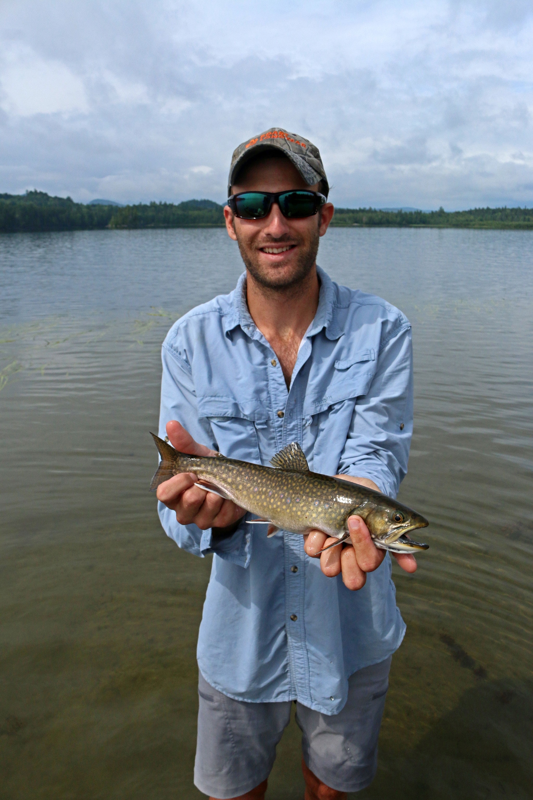 a fisherman with a brook trout on Allagash Lake, Maine