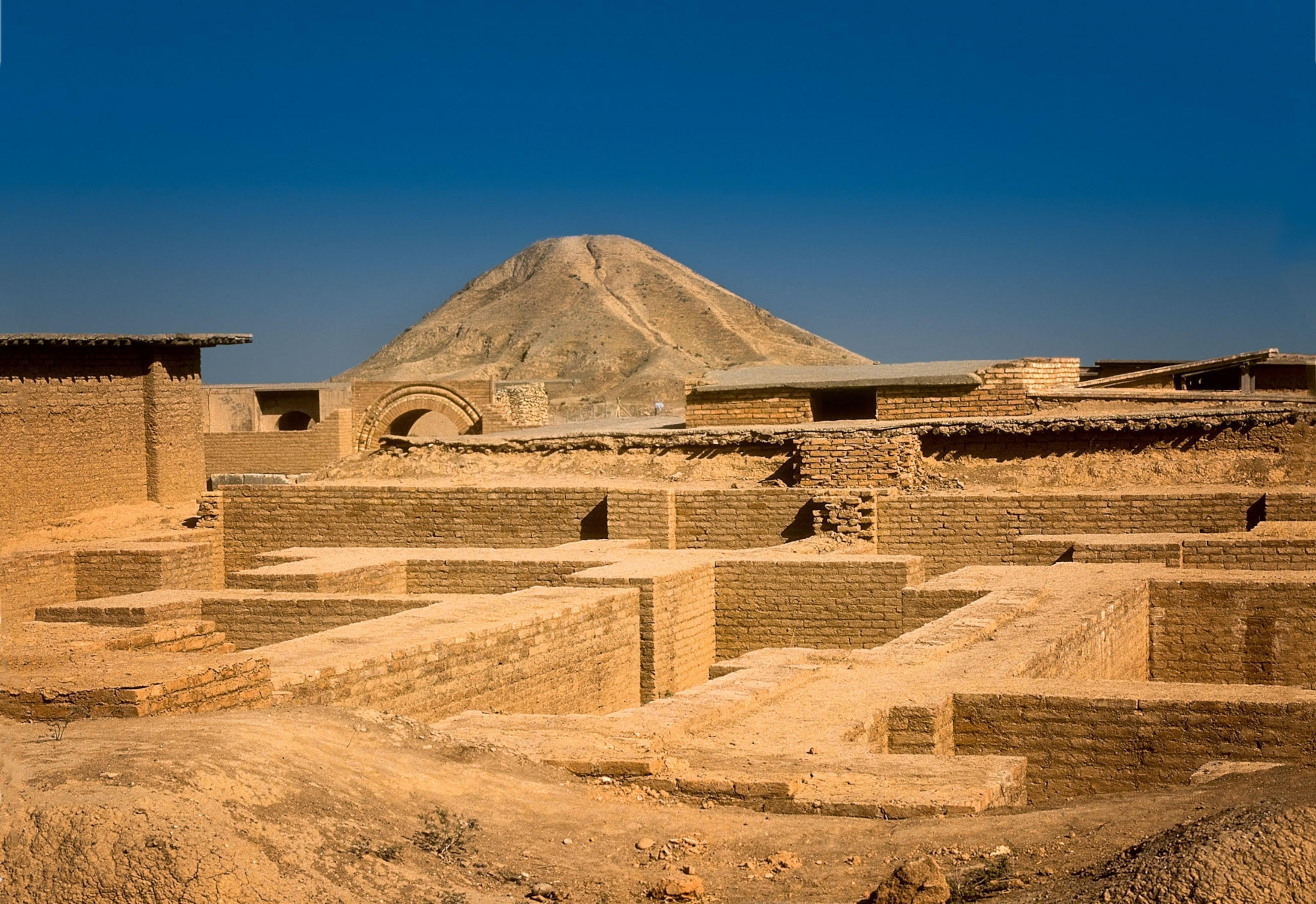 a ziggurat rising behind the ruins of the ancient Assyrian city of Nimrud