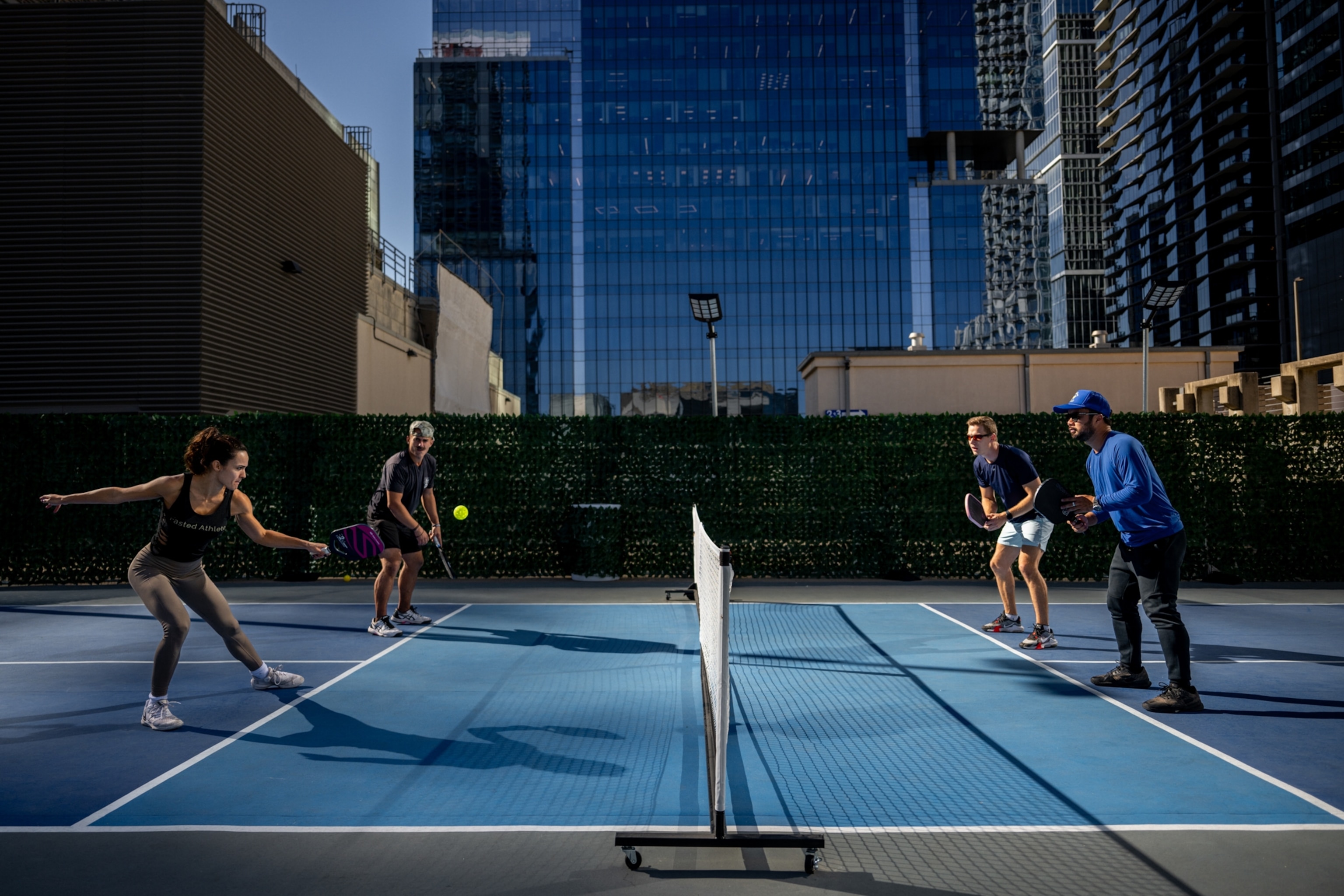 Pickleball players playing on a rooftop pickleball court in downtown Austin.