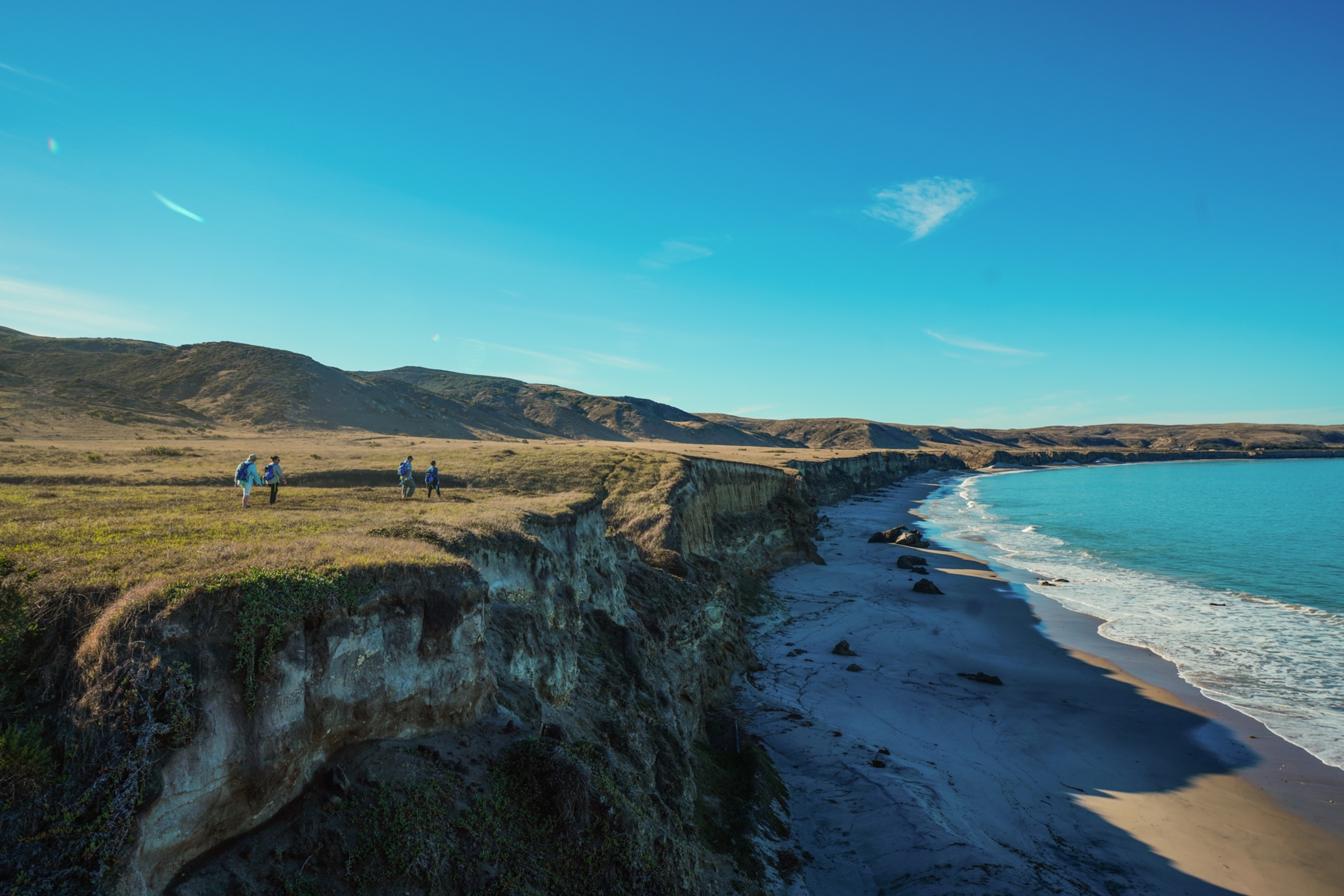 hikers. walk on a cliff overlooking a beach