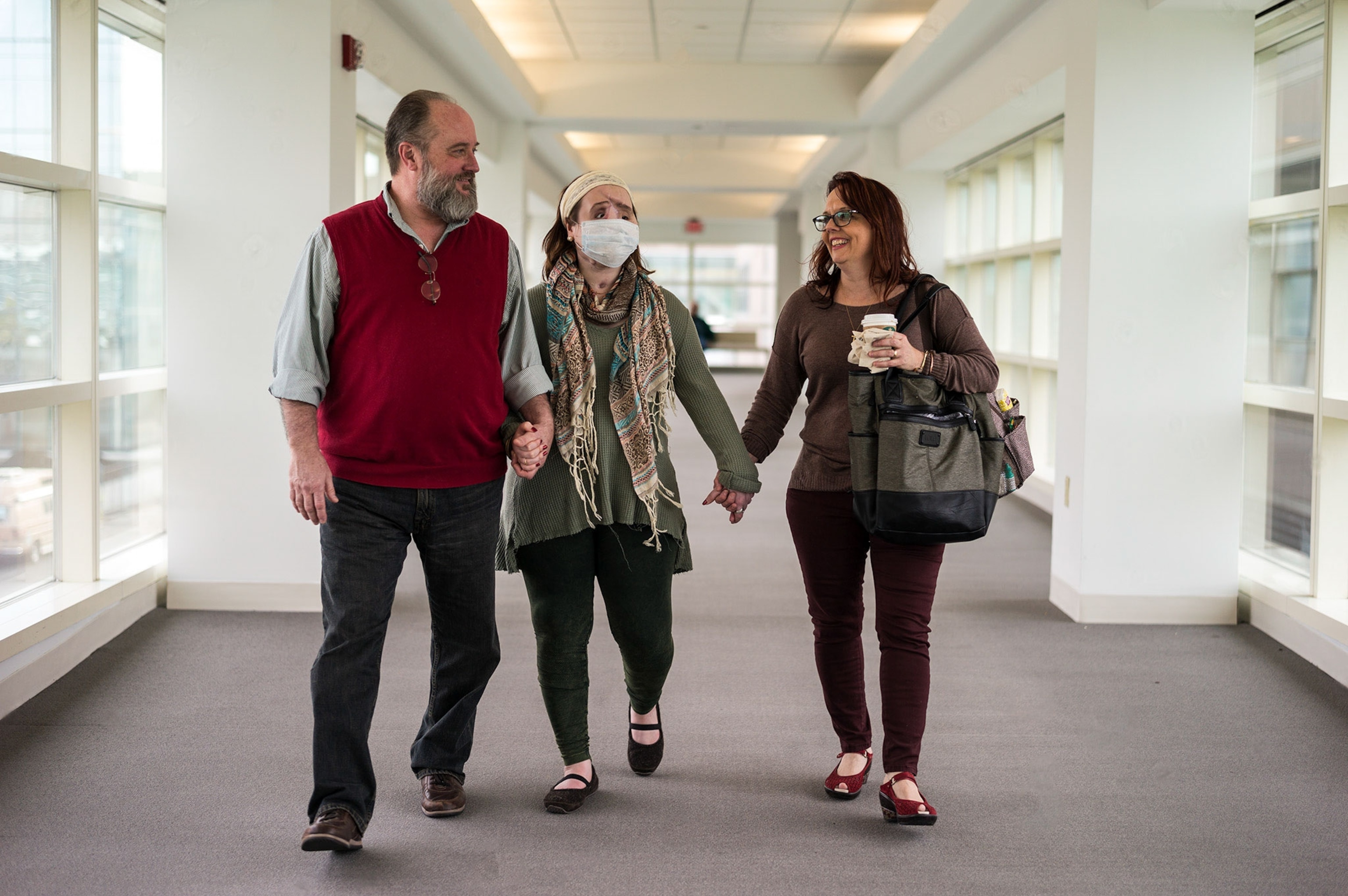 a woman awaiting a face transplant and her parents walking through a hospital