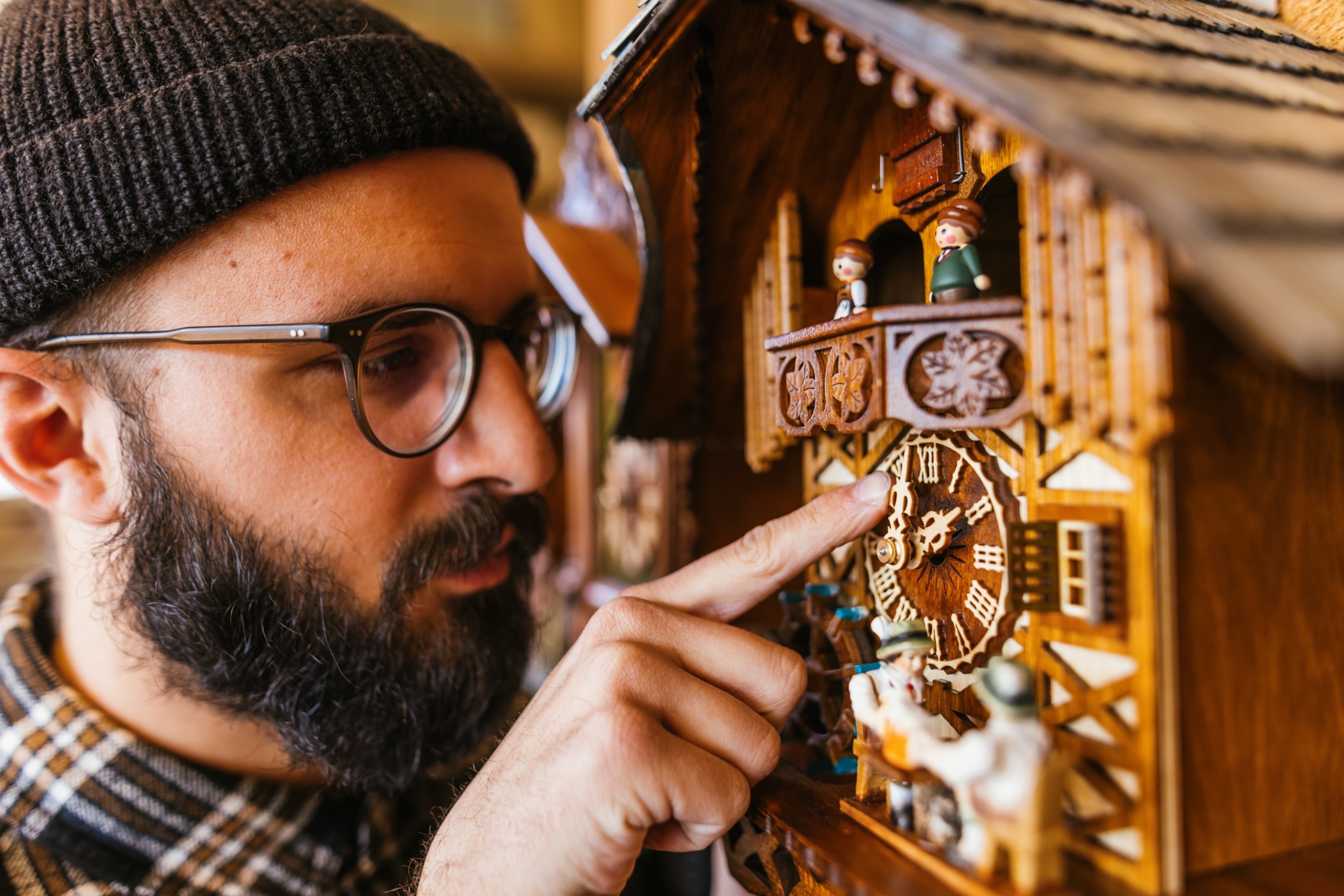 A clockmaker sets the time on a cuckoo clock