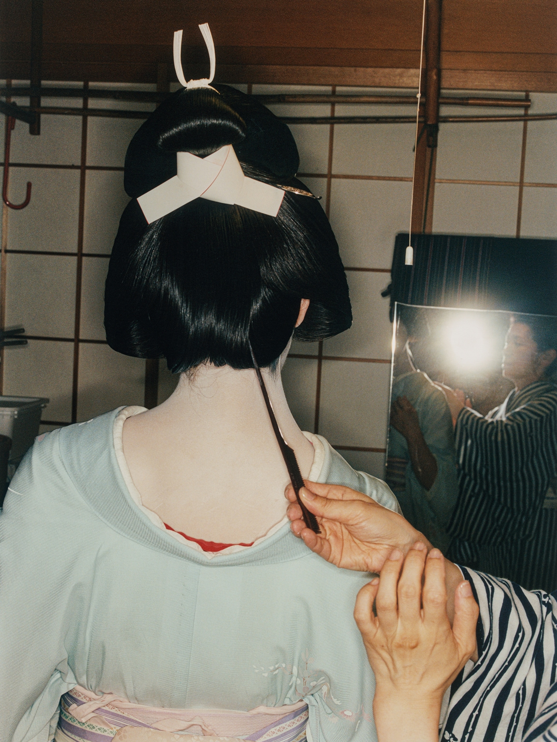 Mikou getting ready with some final hair touch-up, with the assistant of Masami, the owner of Hachishige tea house in Kanazawa.
