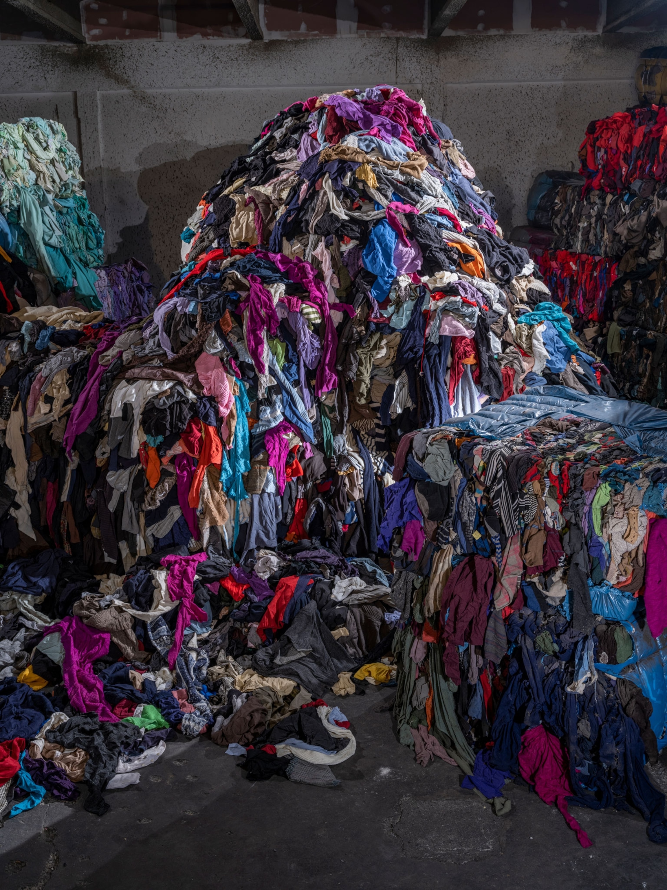 Mountains of used clothing await sorting for recycling.
