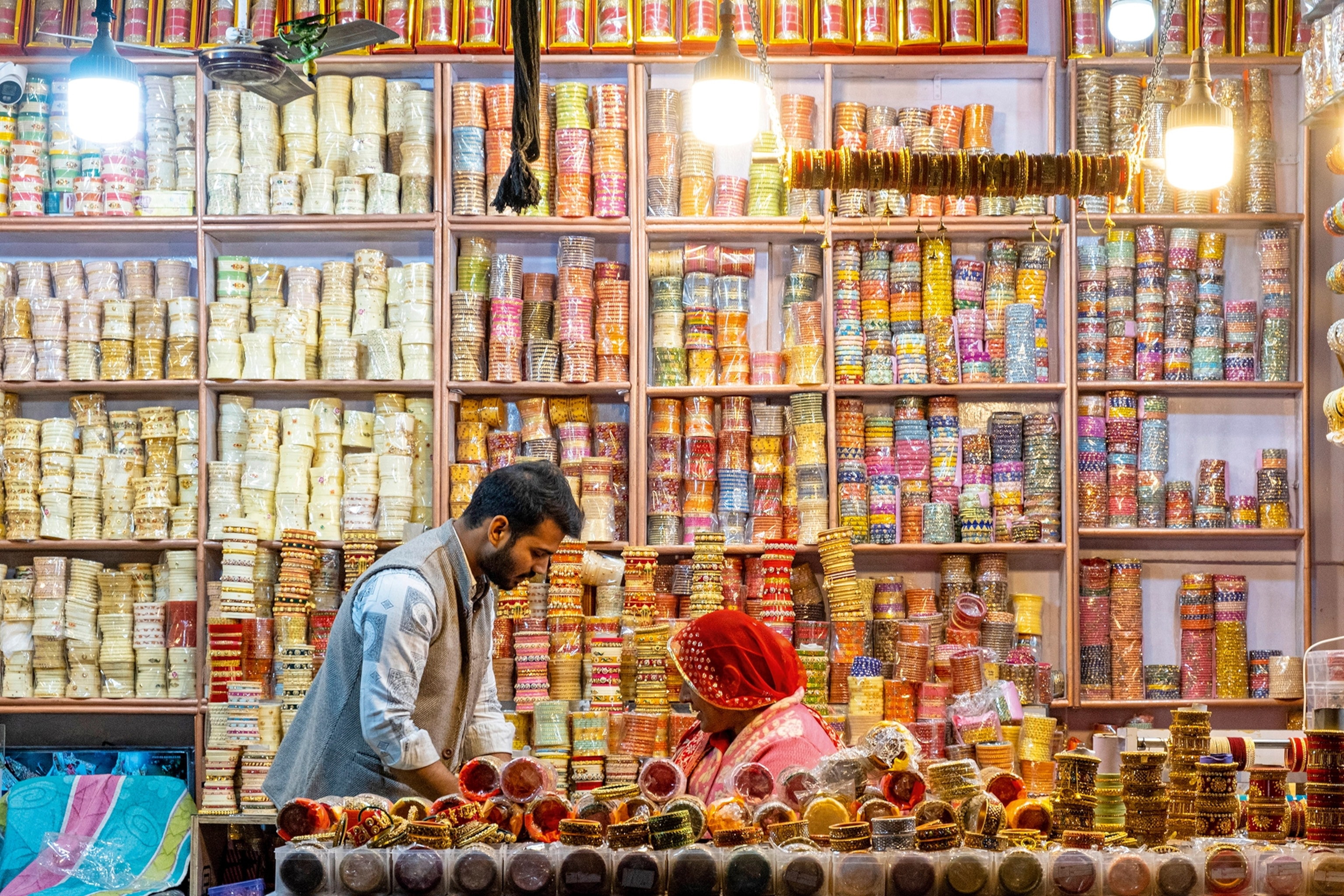 Two men bargaining in a floor-to-ceiling-filled shop of traditional jewelry.