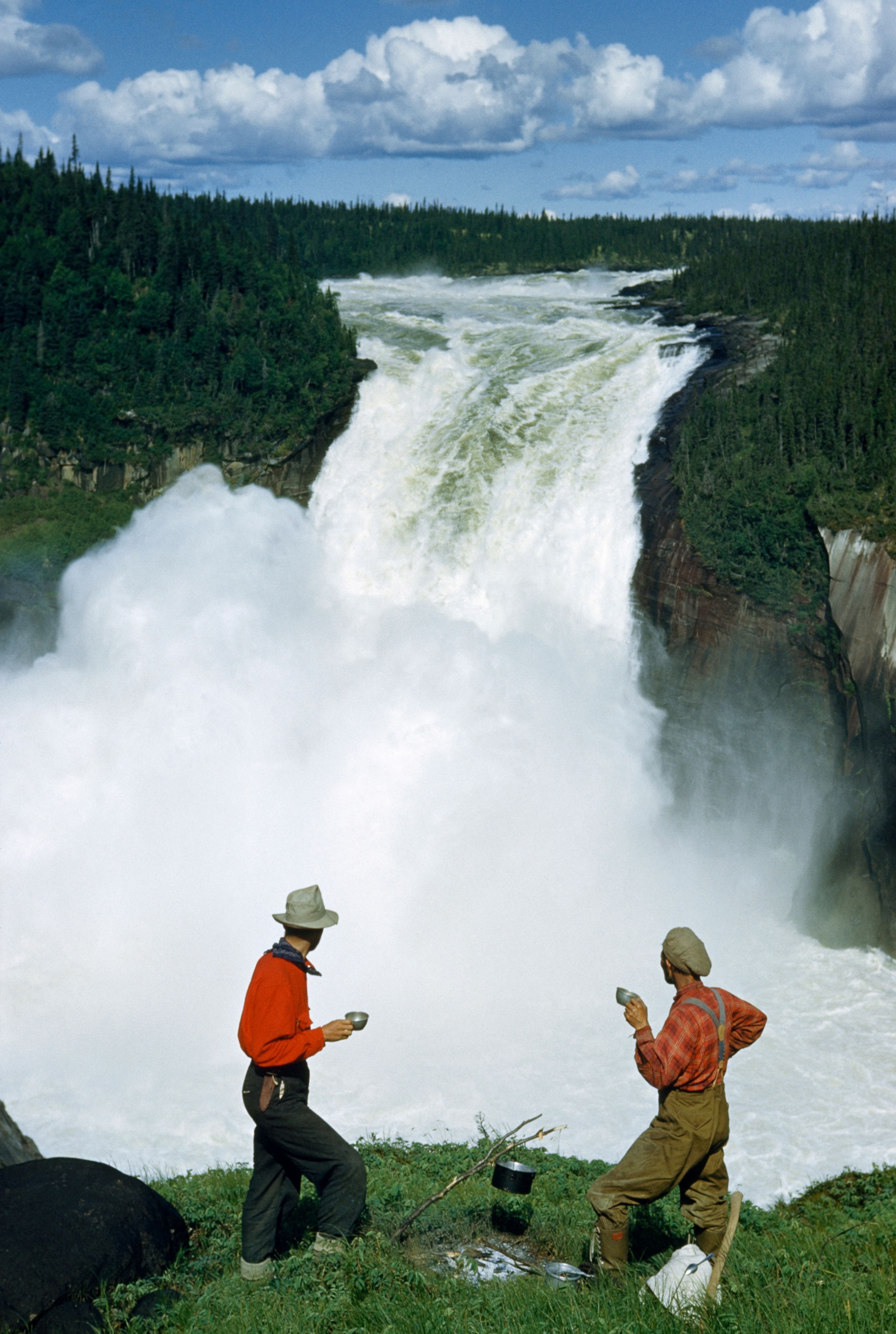 hikers next to a waterfall in Canada