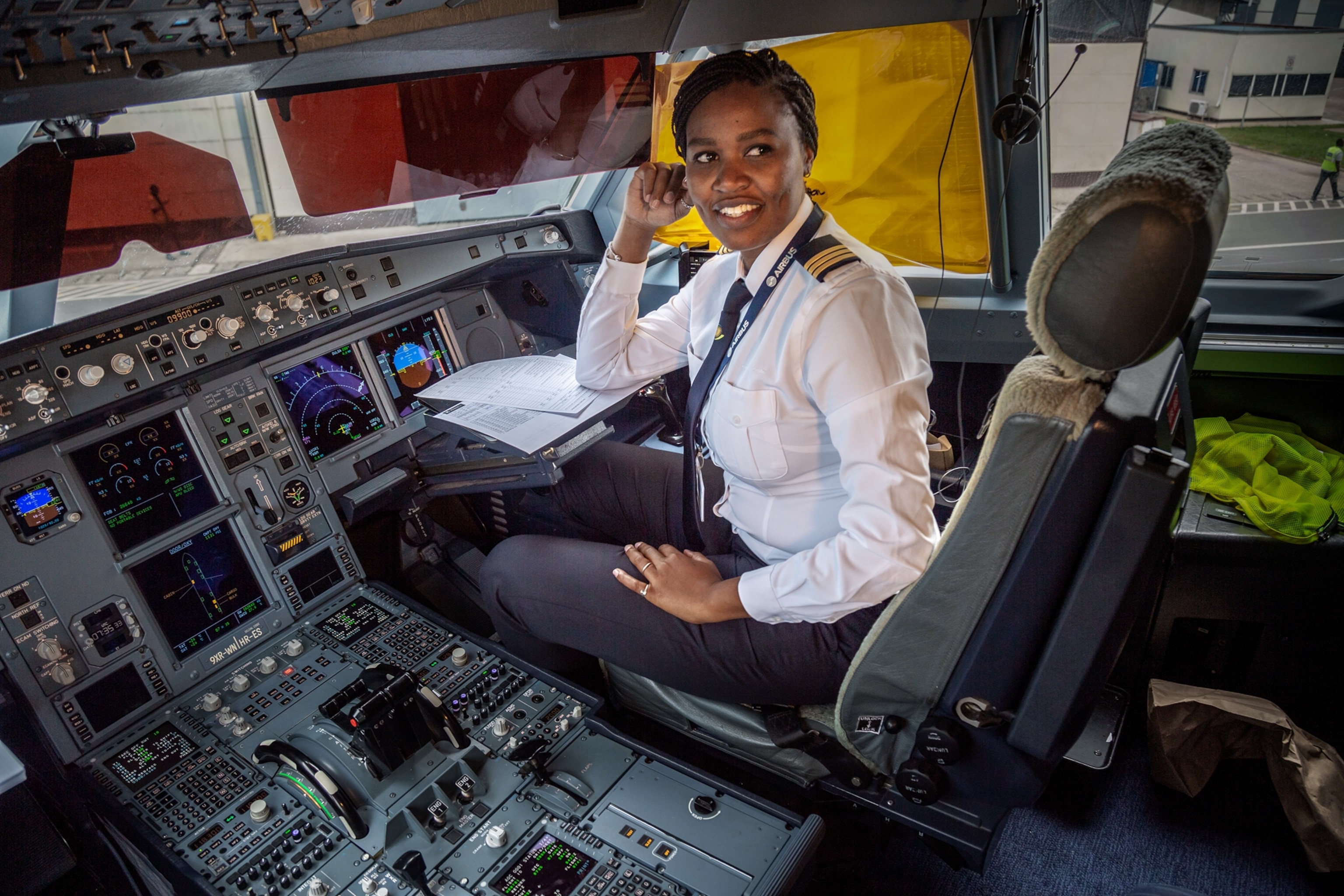a woman sitting in the cockpit of an airplane in park