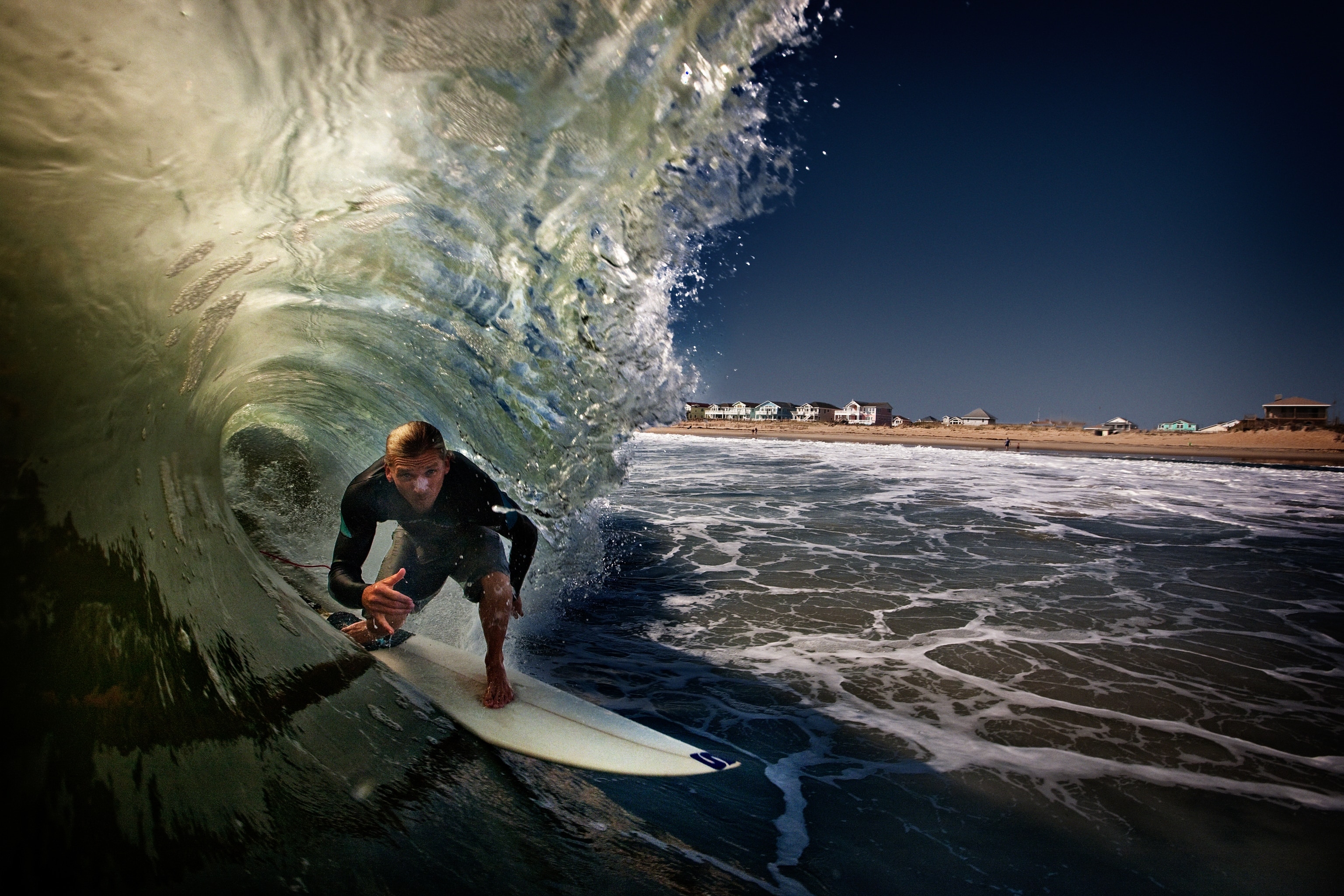 A young man surfs on a wave on the Outer Banks of North Carolina