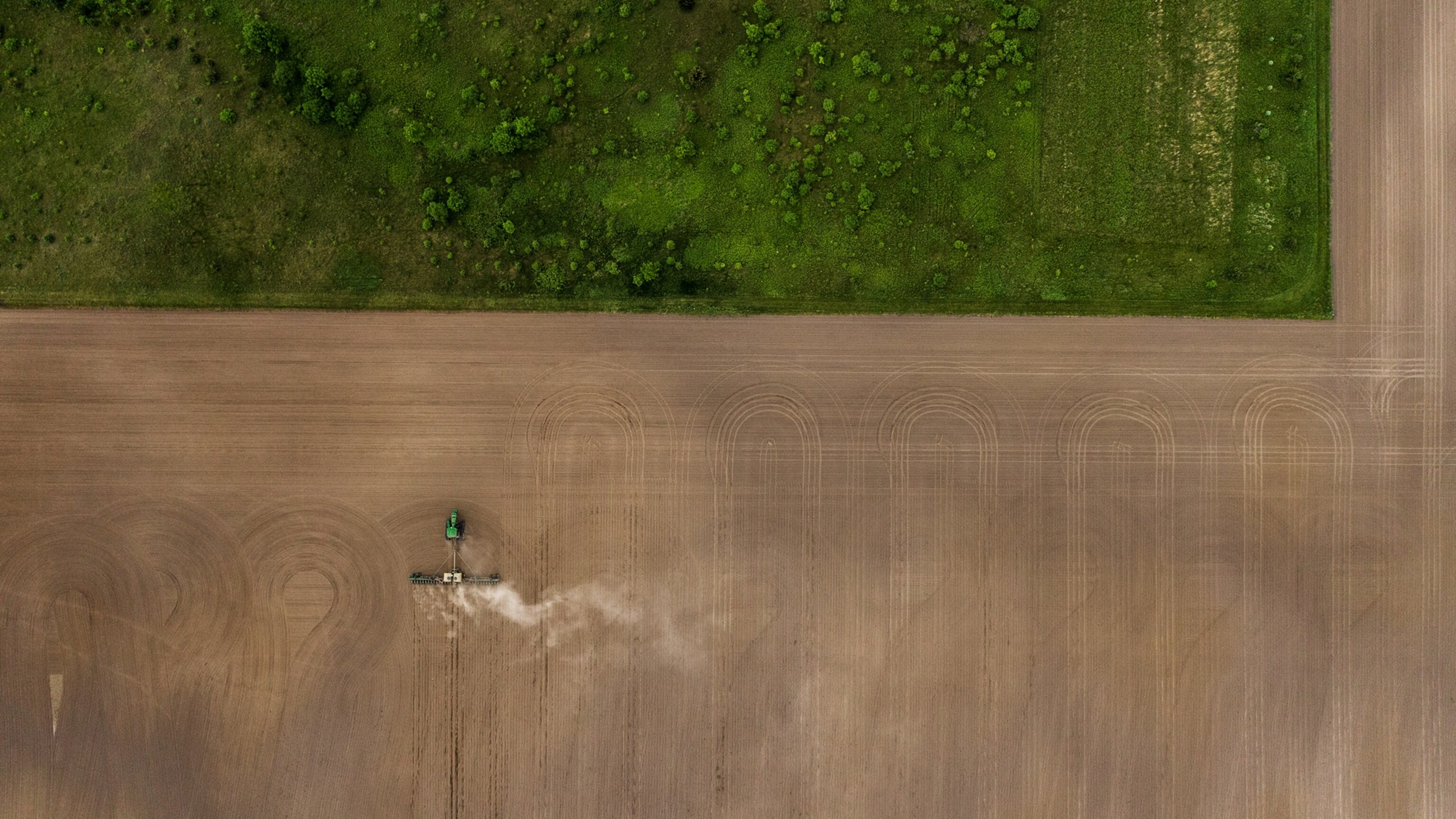 aerial view of brown field next to green one.