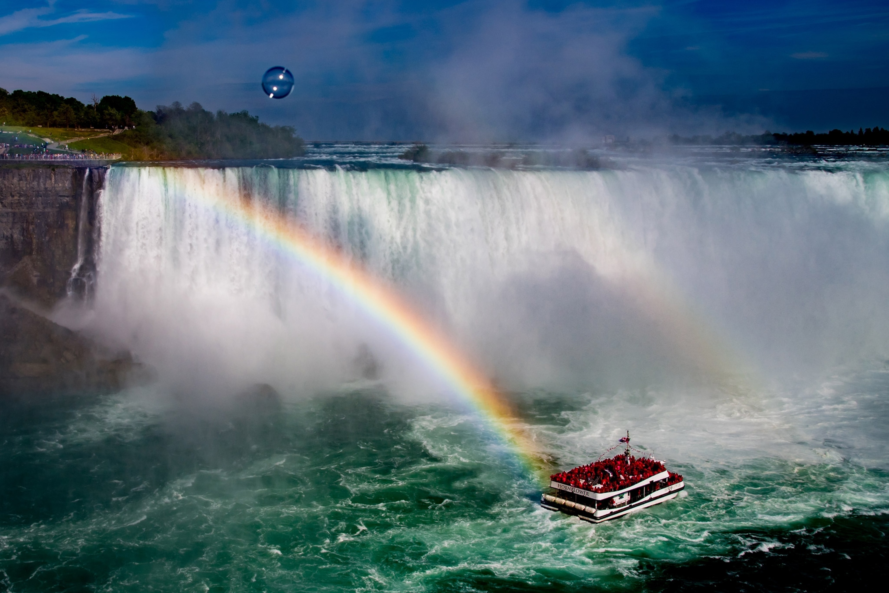 Niagara Falls, a boat of tourists, and a rainbow as seen from Niagara Falls, Ontario