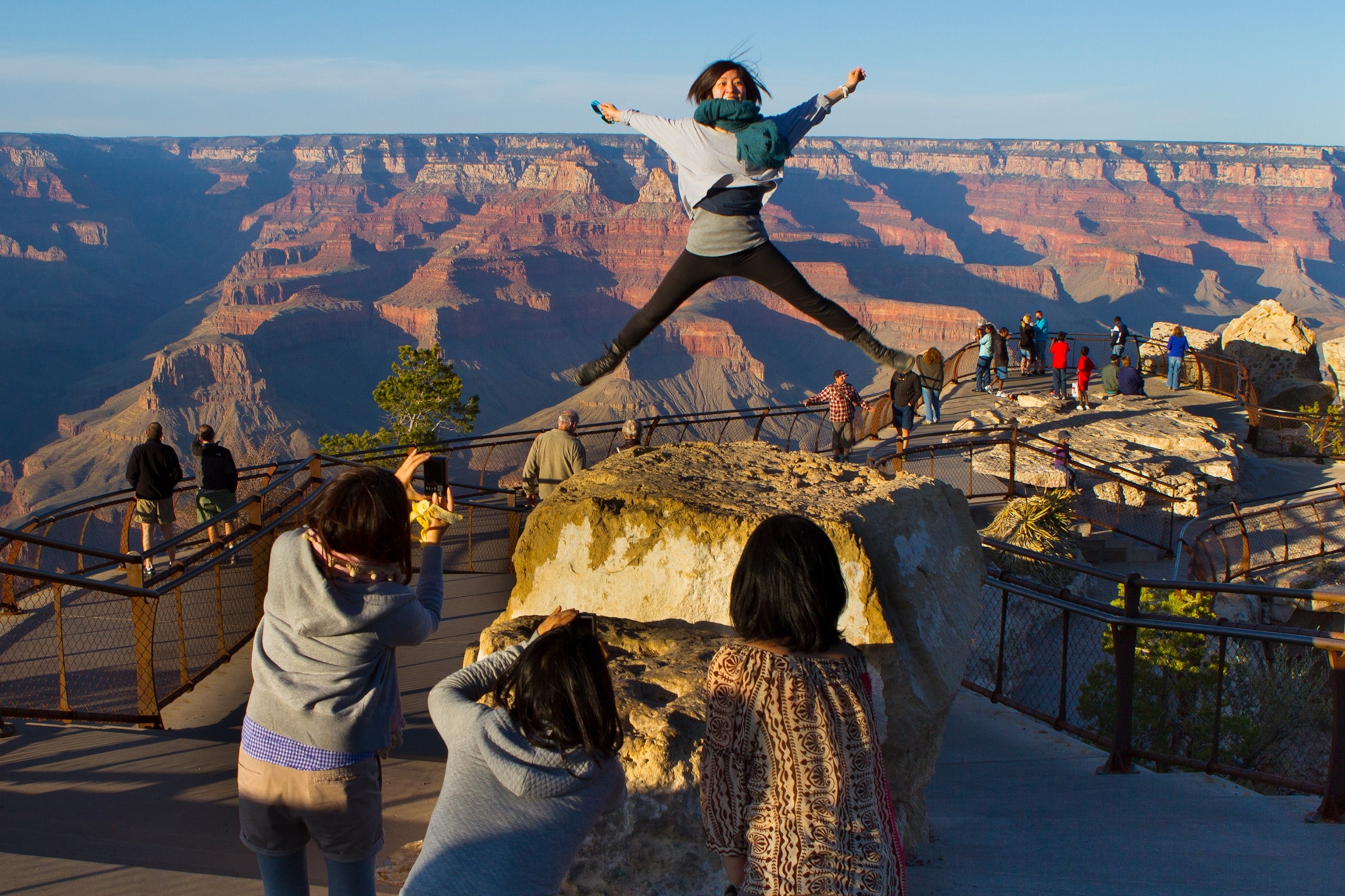 The mountains are in the background as woman jumps in the foreground.