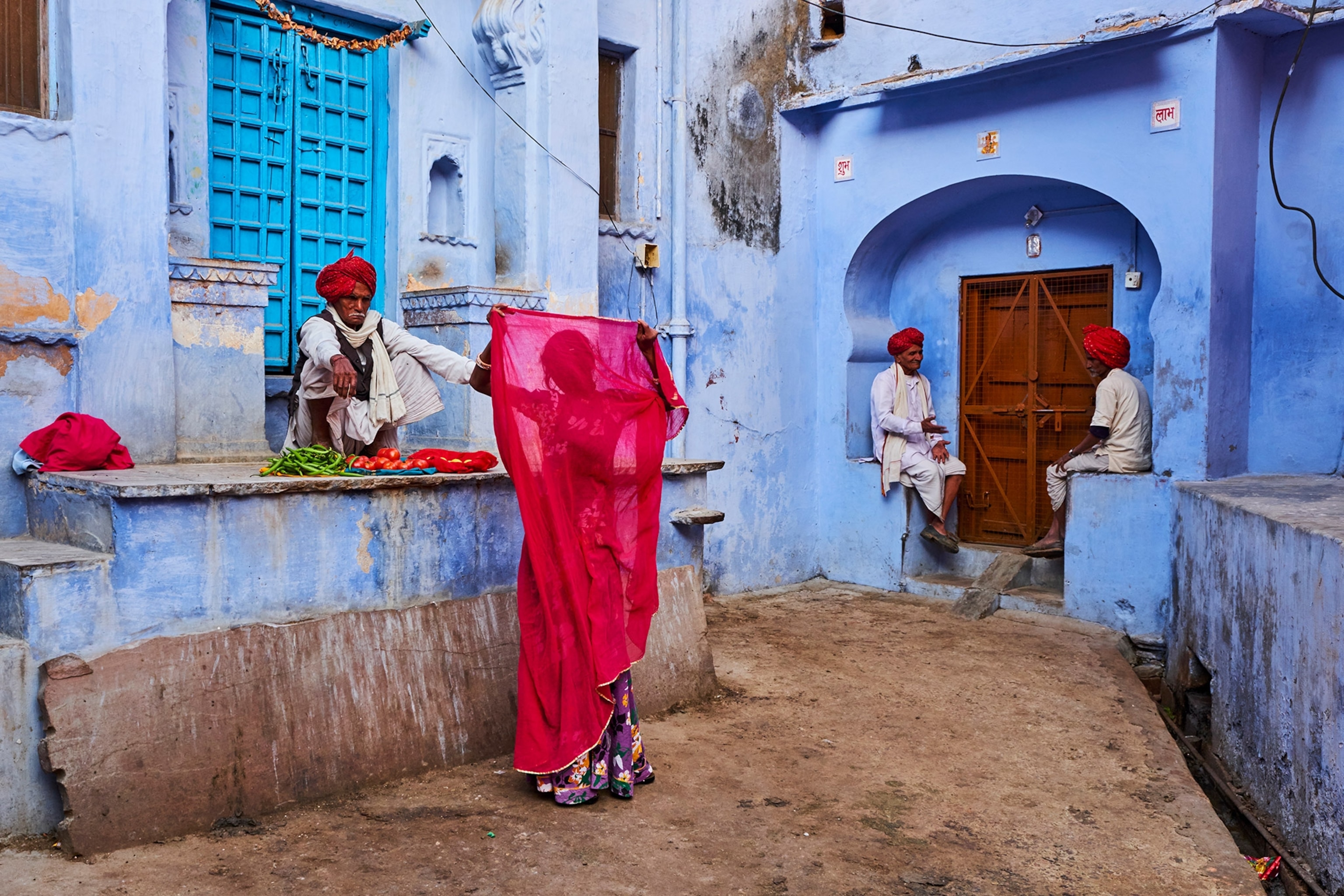 A woman holds up a sari in the street in Rajasthan, India