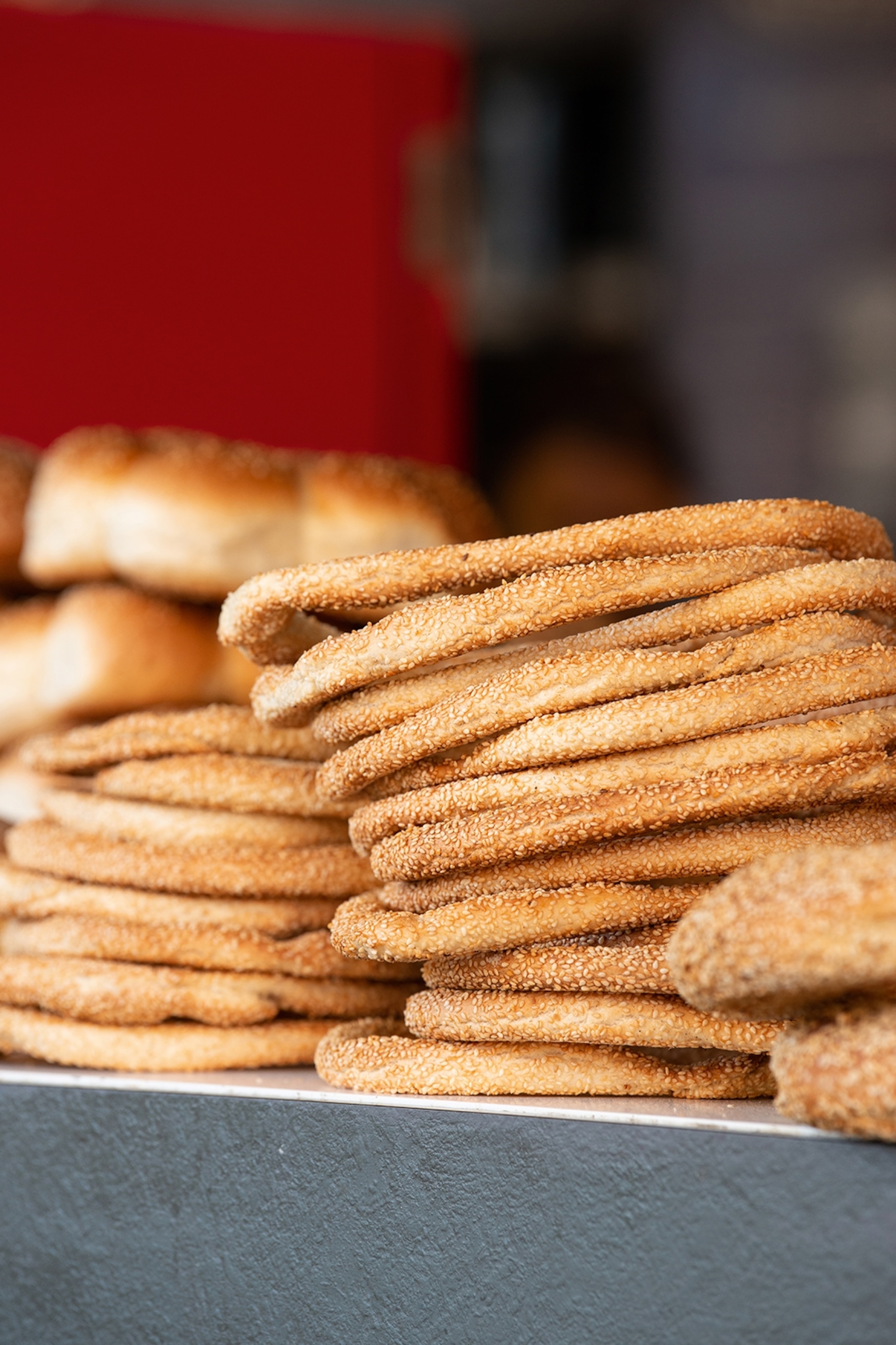 Stacked, backed sesame ring pastries on a counter.