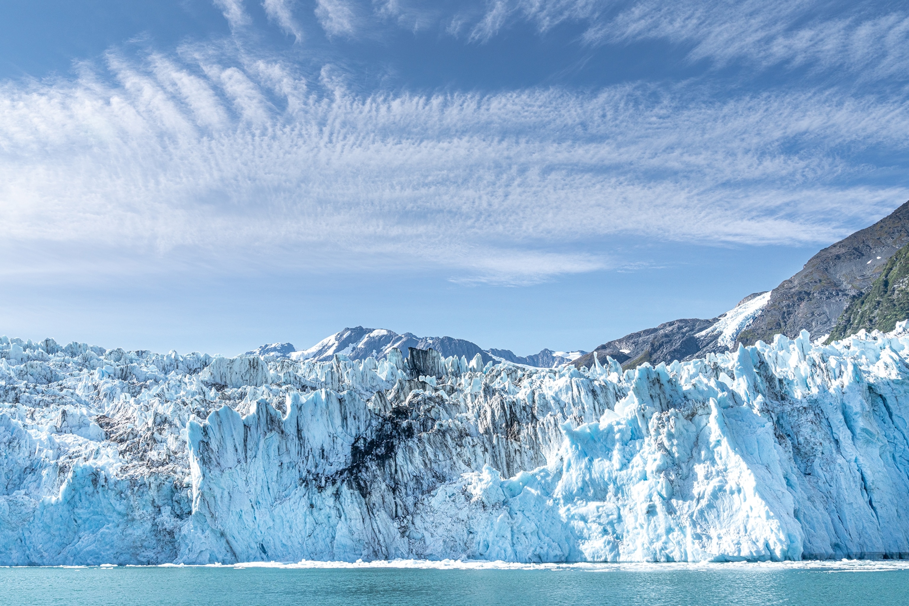 The face of an imposing glacier bordering with the icy sea.