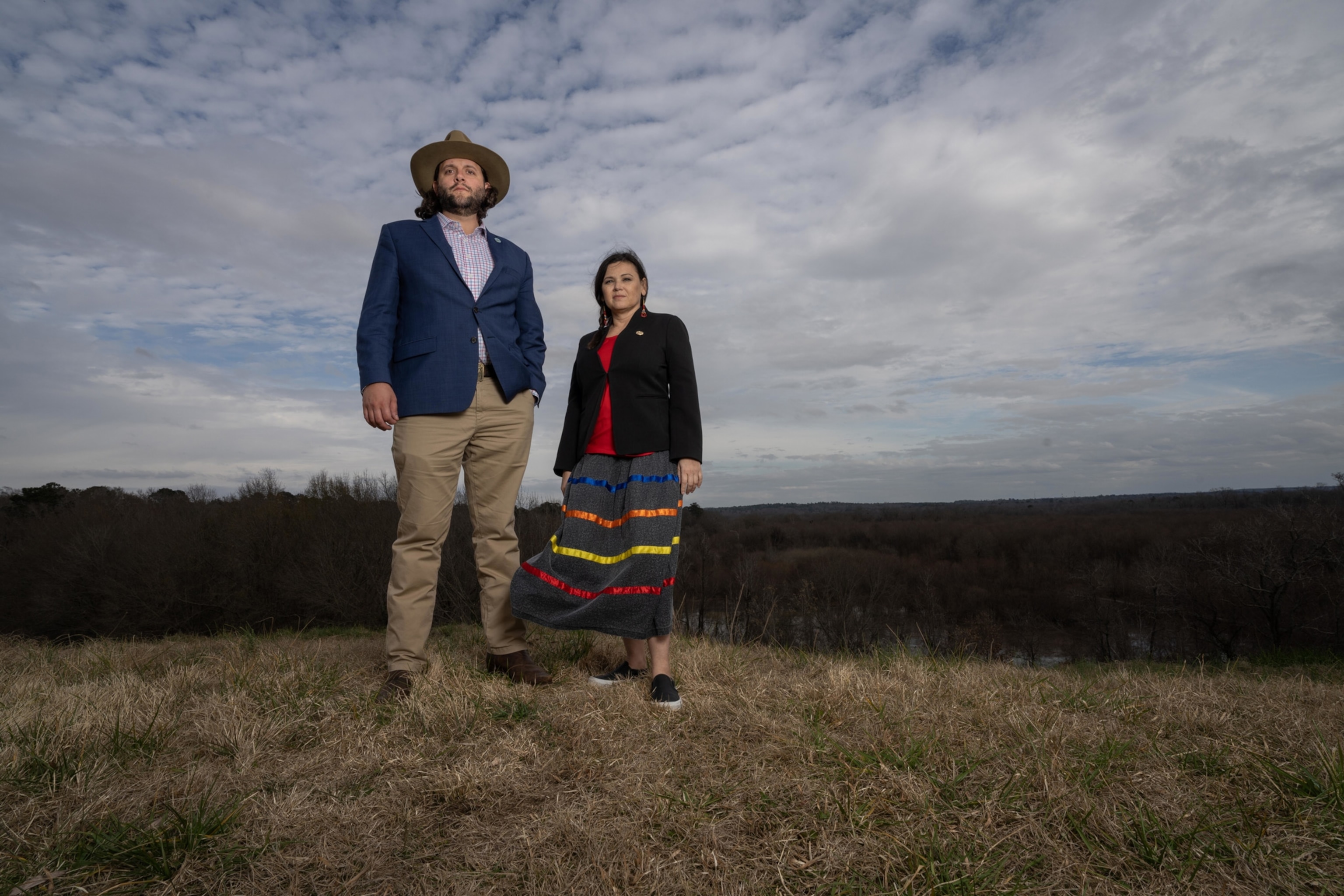 Photo of man wearing hat next to woman wearing skirt with stripes