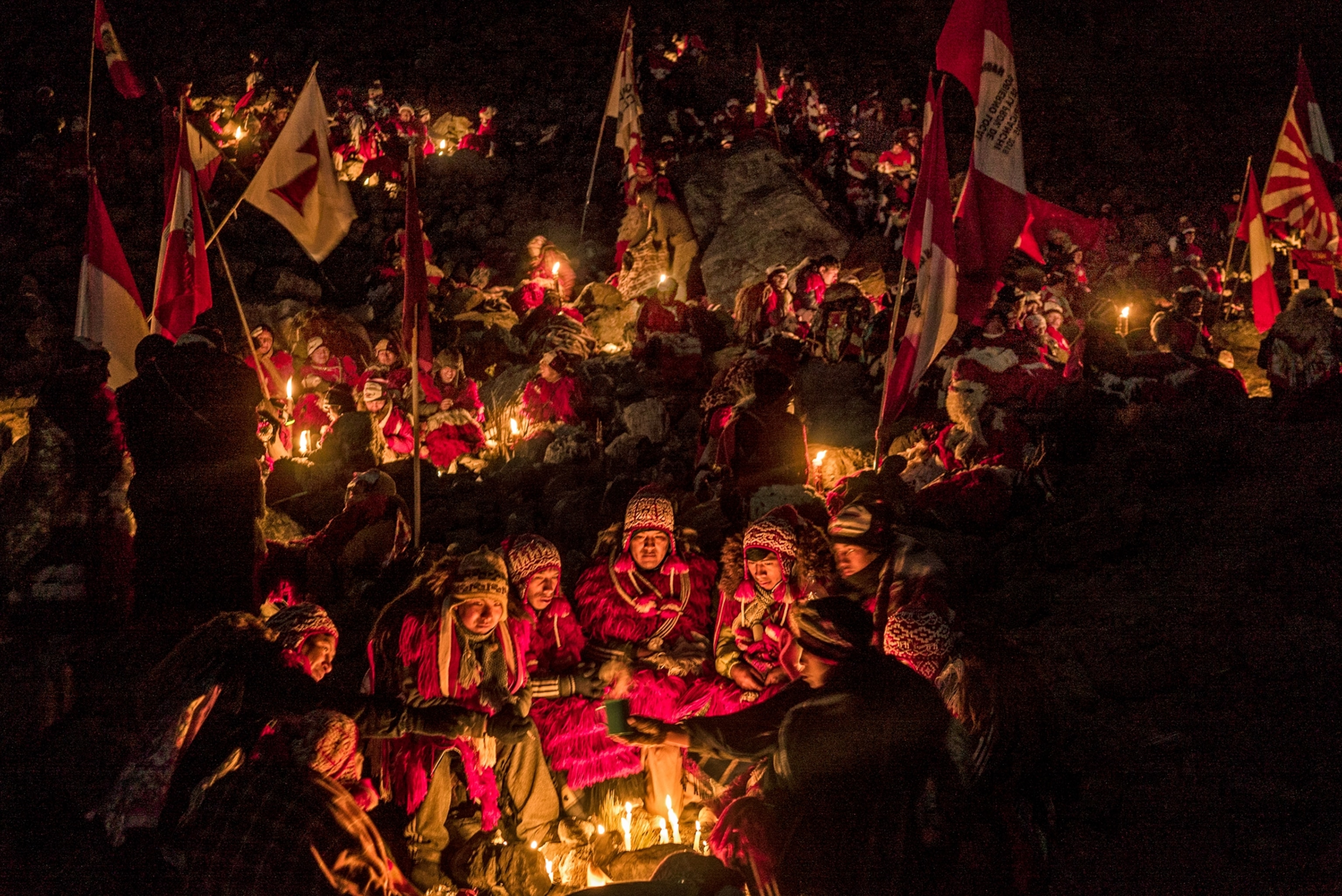 group of people in traditional costumes around campfire.