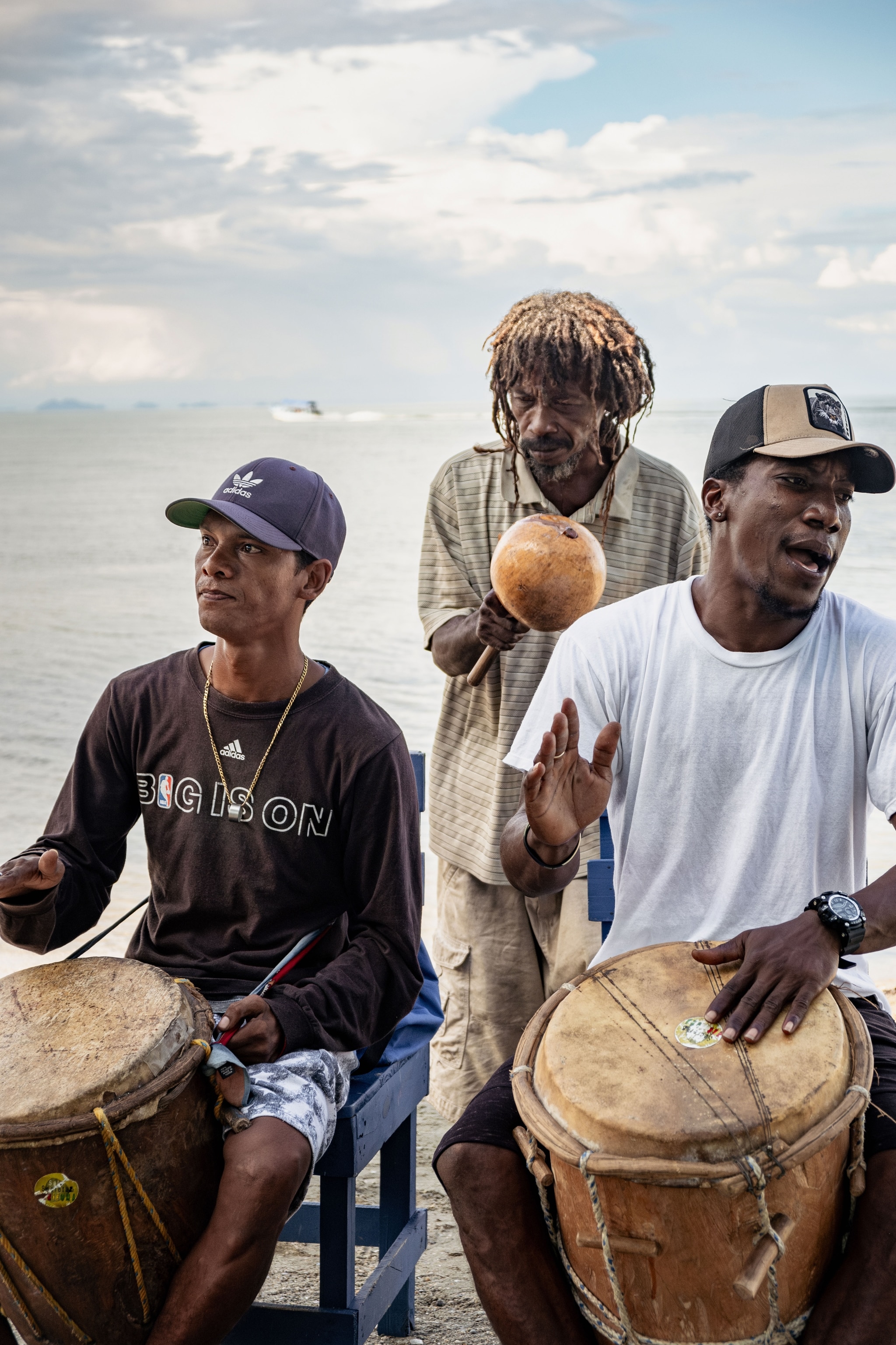 Bandmates Chuleta, Alfonso and Kyoto play Garifuna music on the beach by La Playita de Barique.