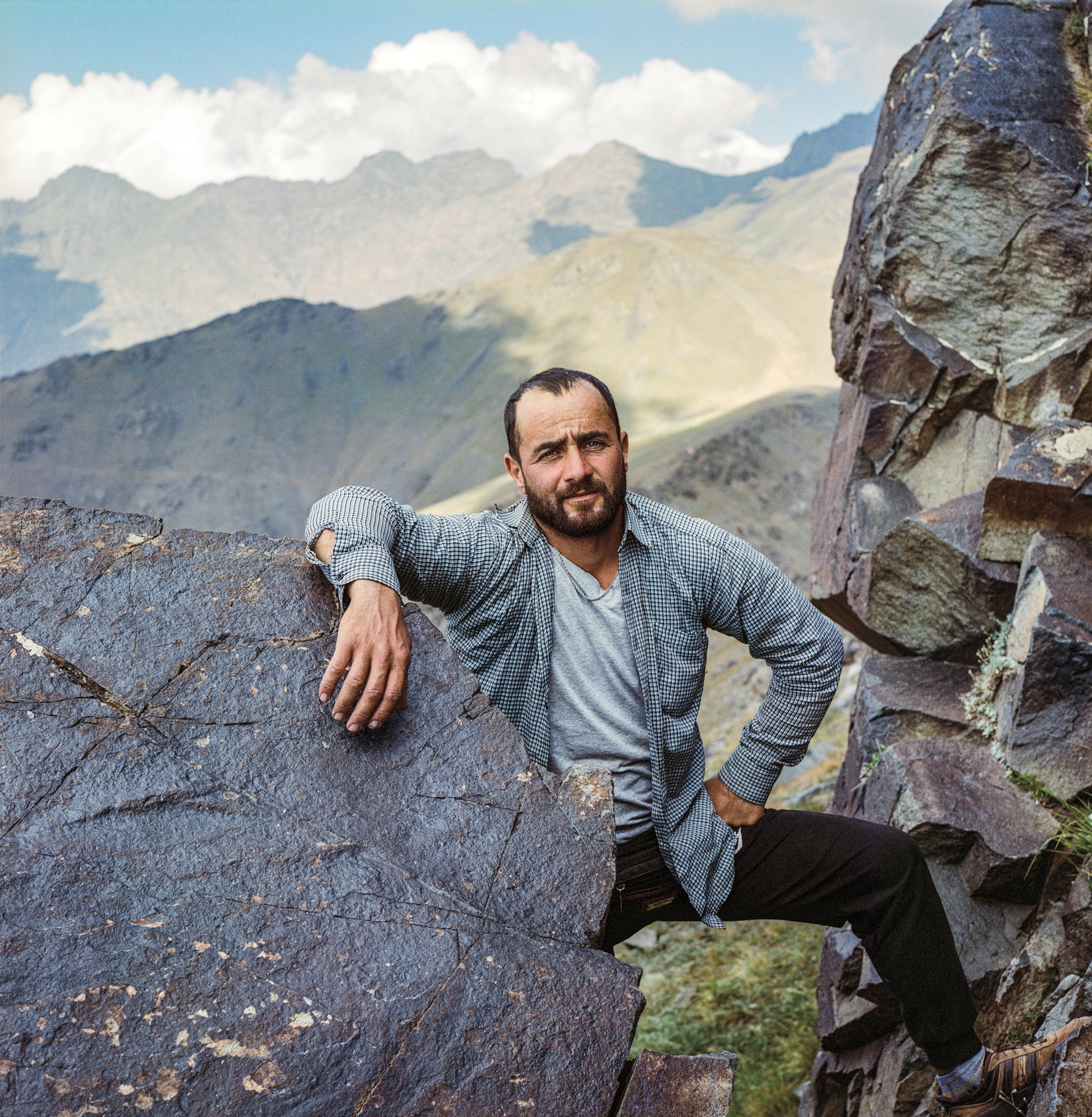 A man stands for a portrait in the mountains.