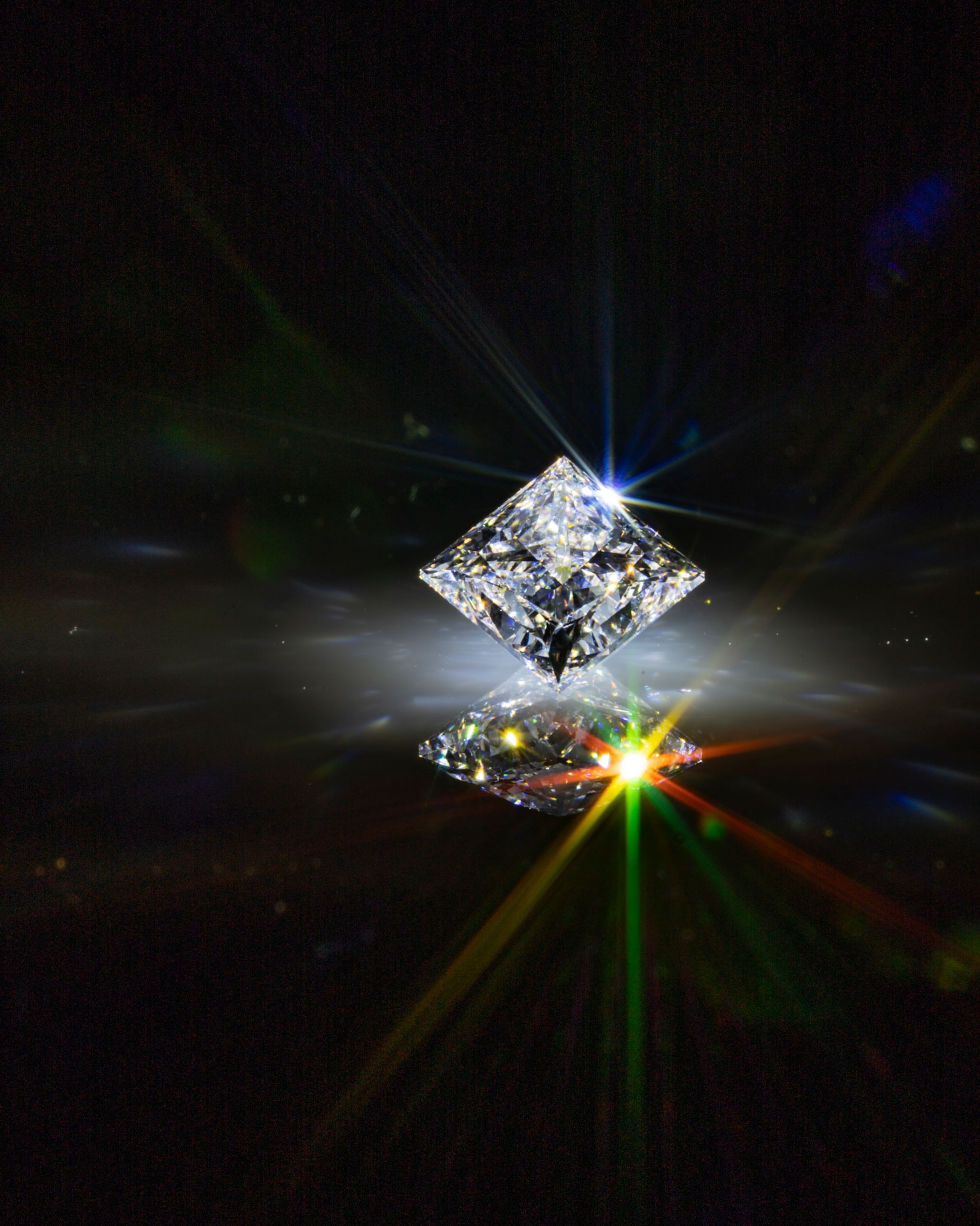 a synthetic diamond reflects rainbow shine on a black background
