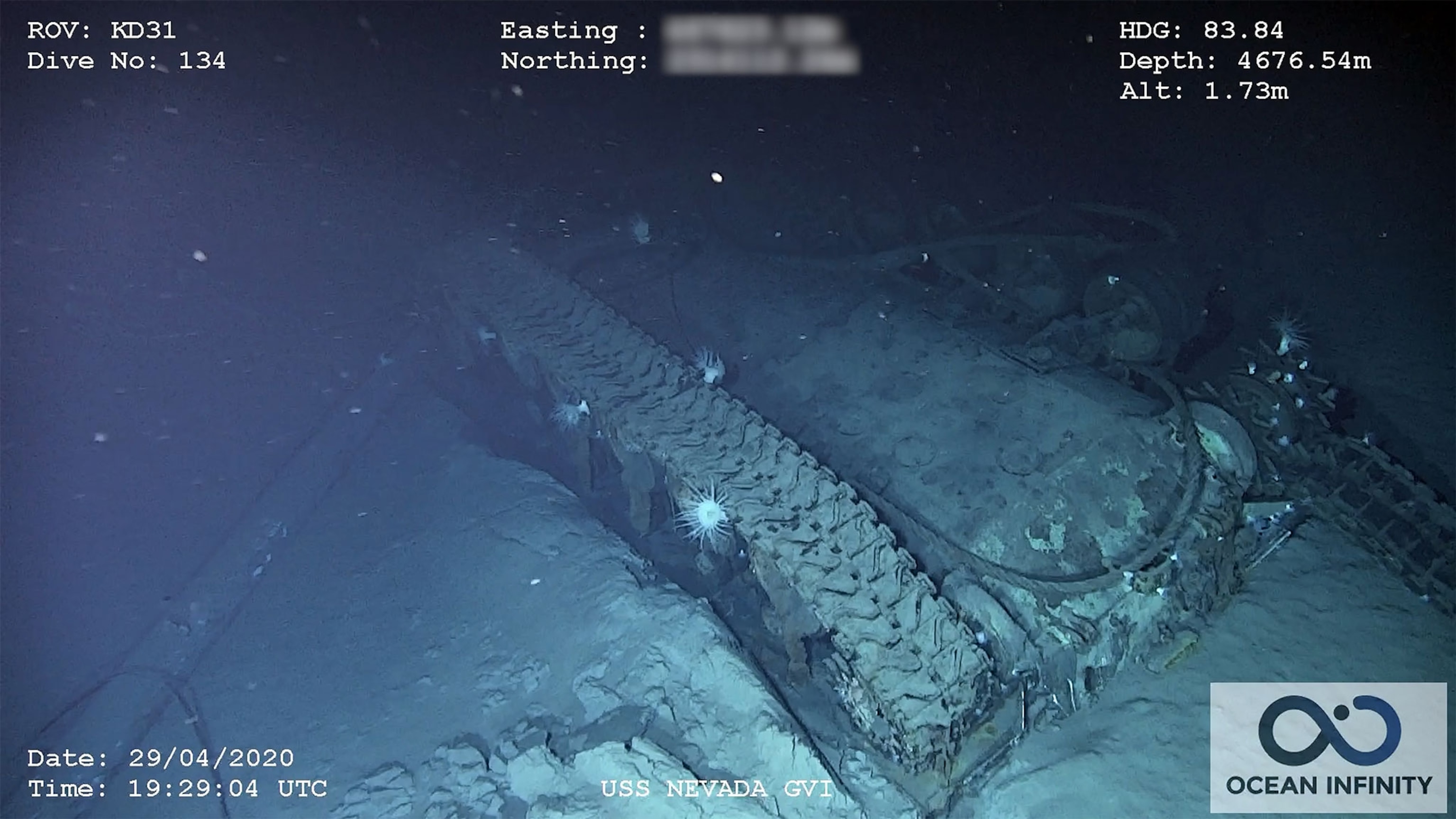 An underwater picture of a muddy tank flipped over on its back