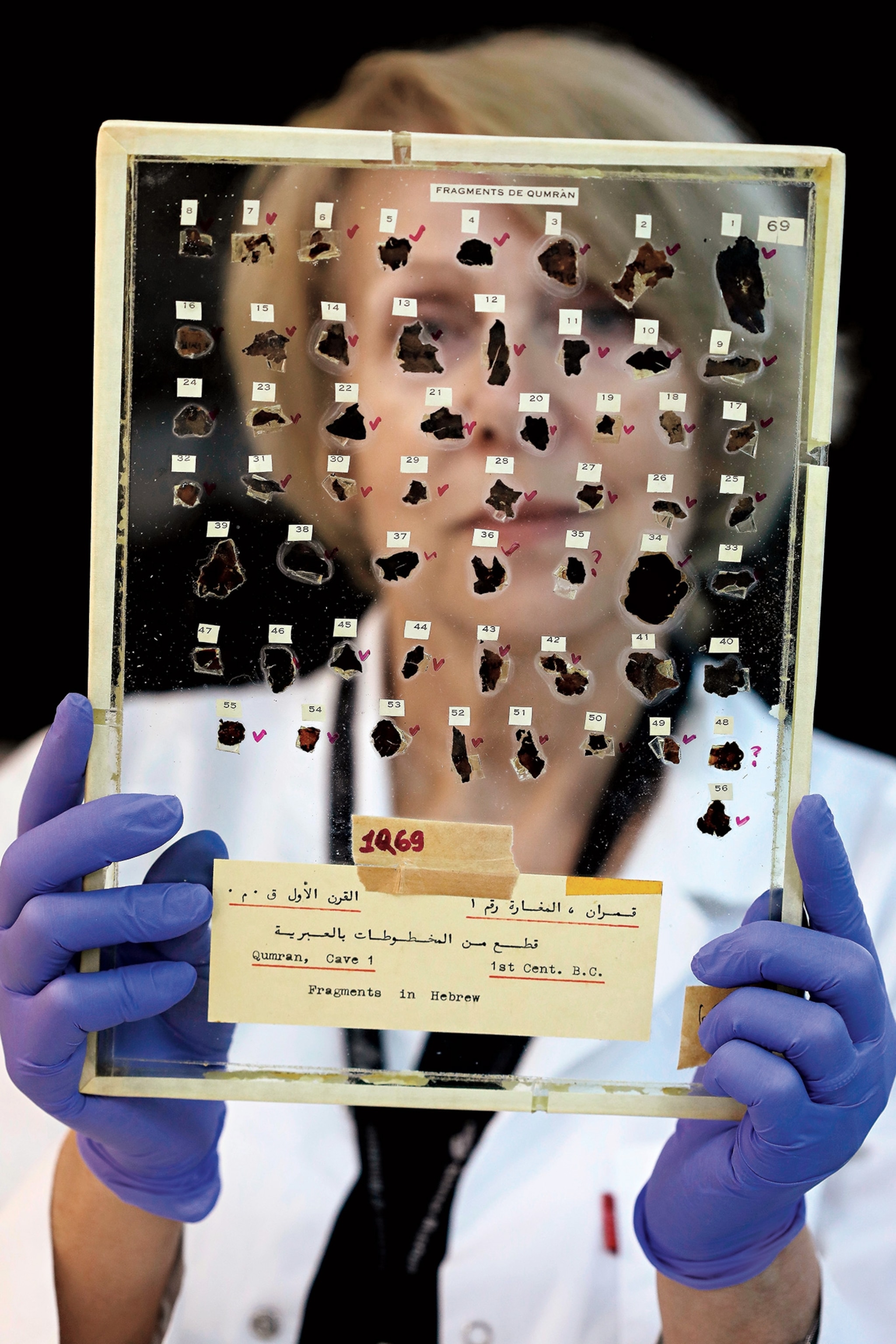 Tatyana Bitler, a conservator of the Israel Antiquities Authority (IAA), handles fragments of the Dead Sea Scrolls at their laboratory in Jerusalem in 2020.