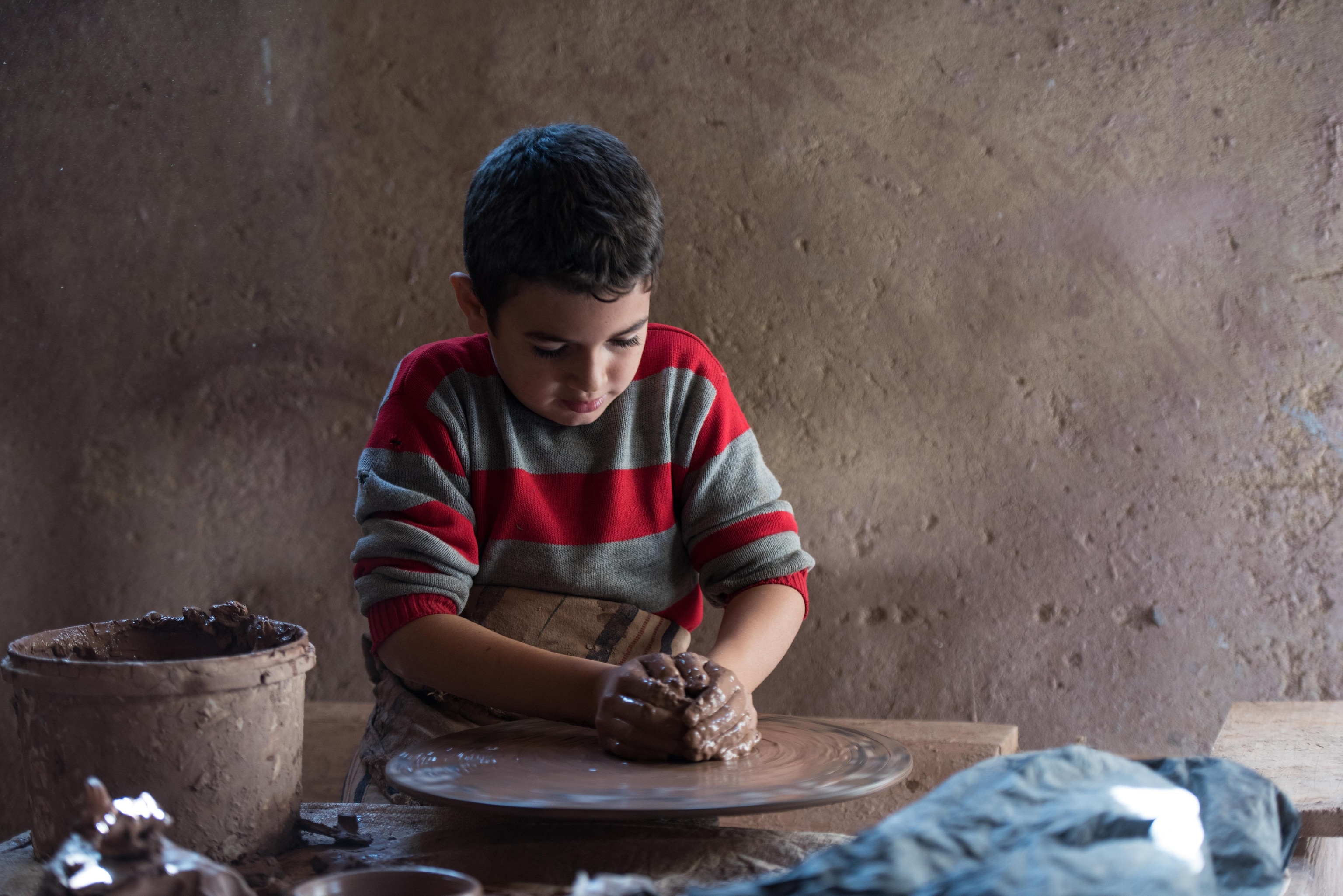 even-year-old Adam el-Sherif makes pottery at Mahmoud el-Sherif's Pottery Workshop in Fayoum