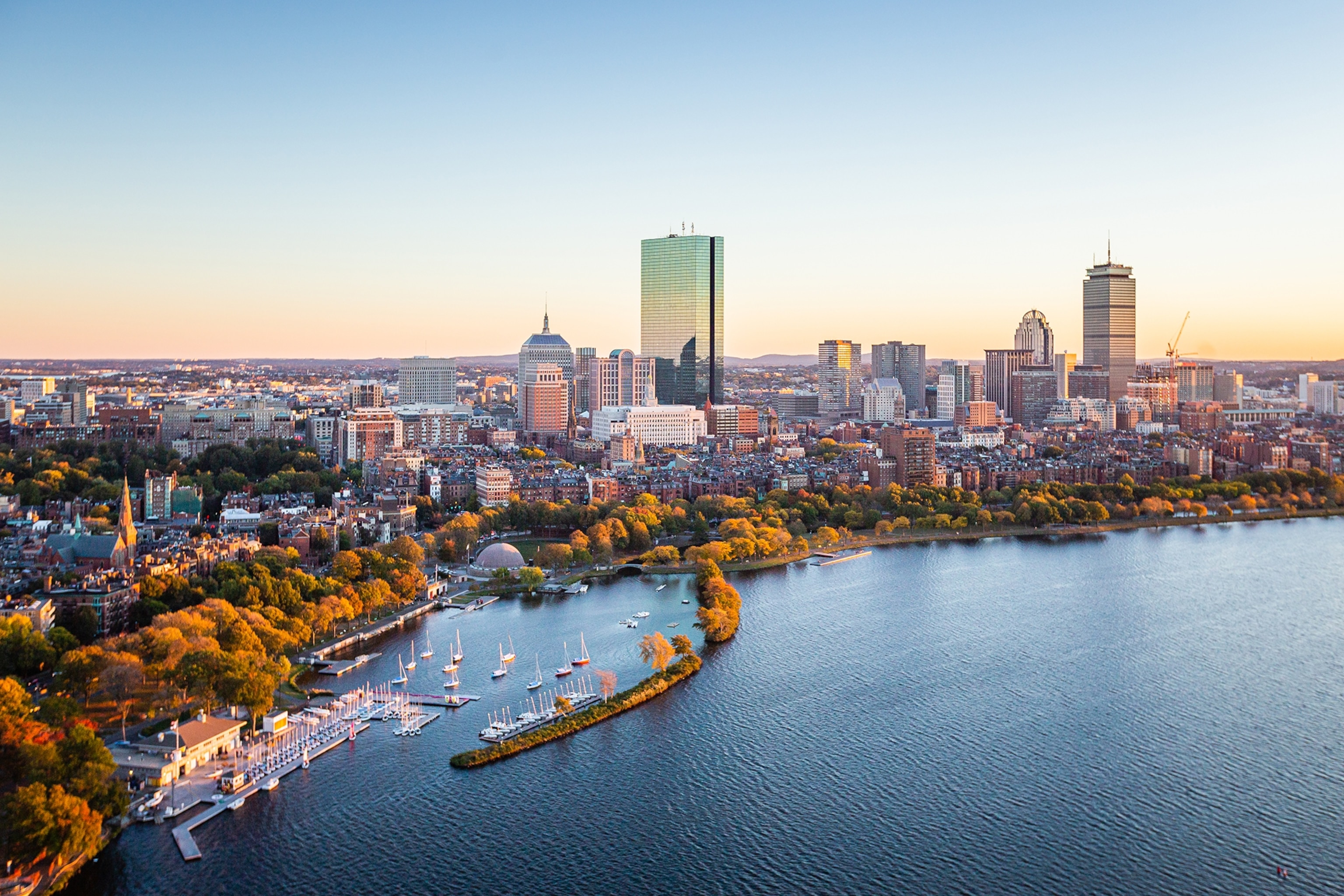 City and a river at sunset with high rises and autumn coloured trees