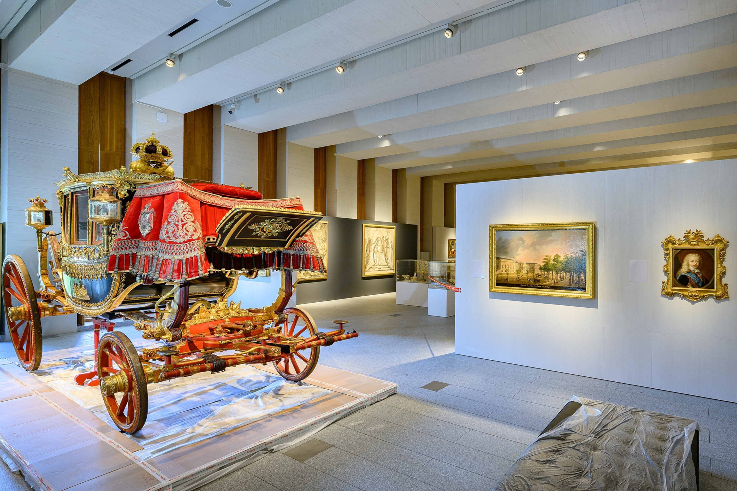 A carriage and paintings inside the Royal Collections Gallery in Madrid, Spain.