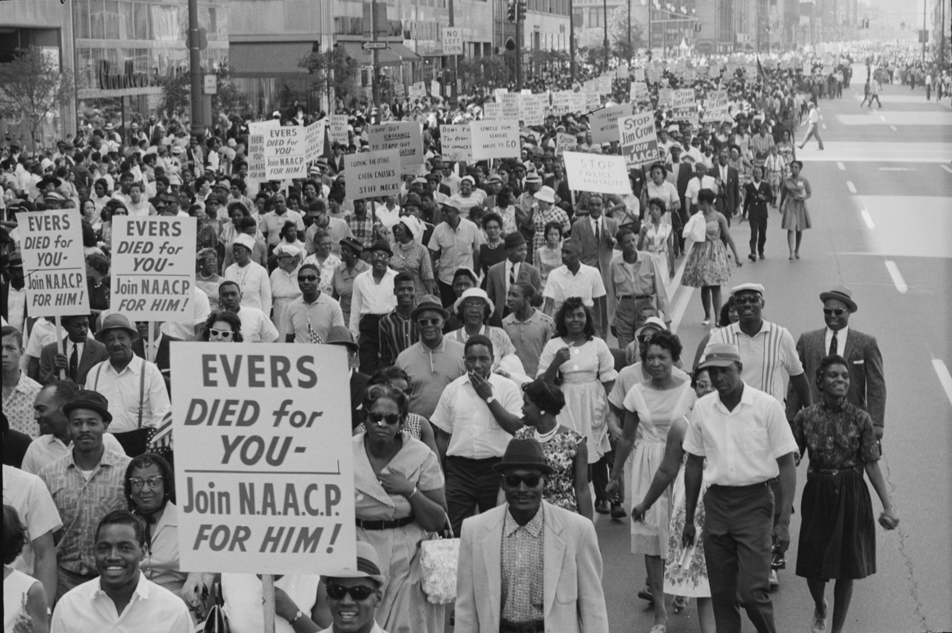 a large crowd marching holding signs