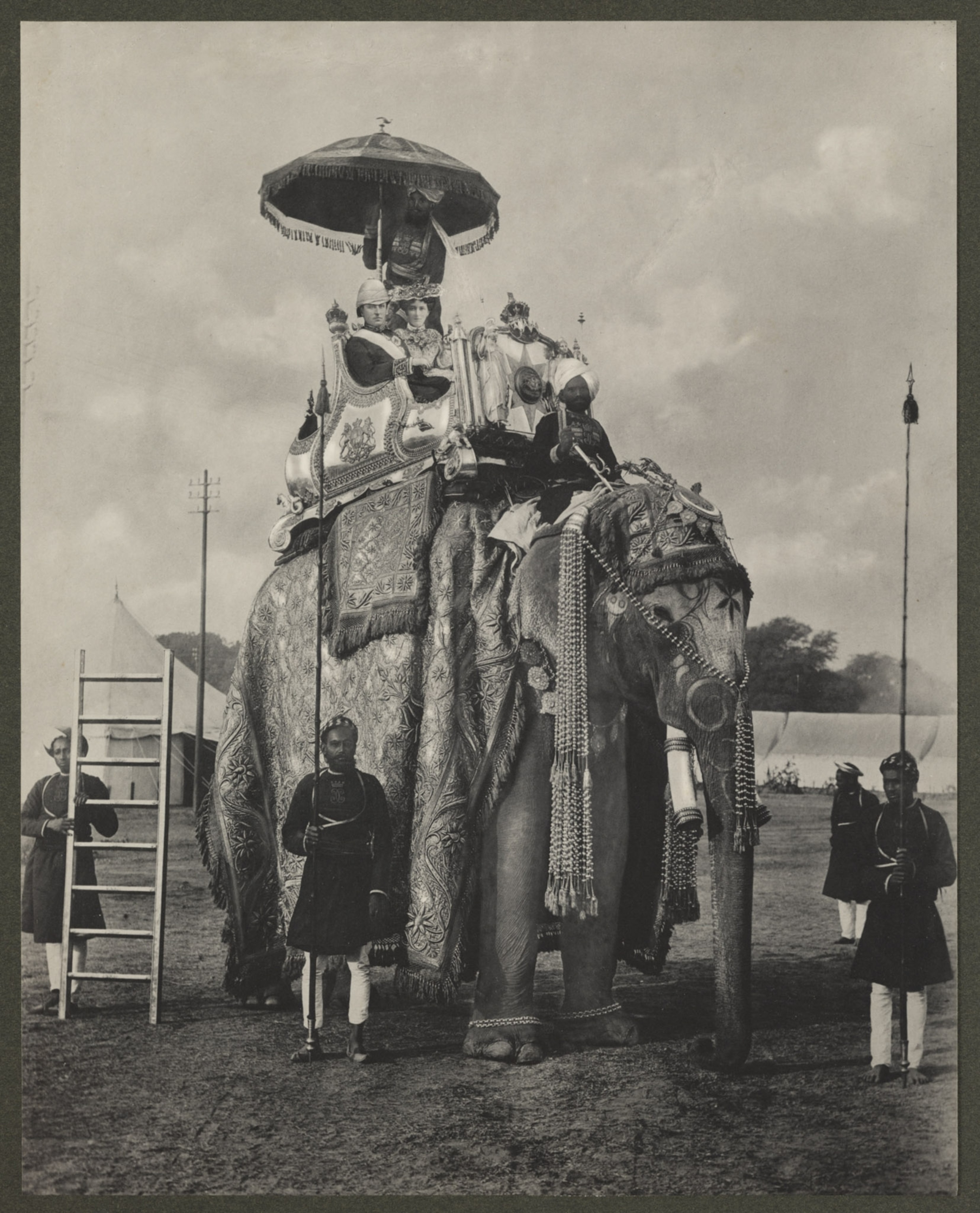 black and white photo of couple on top of very adorned elephant