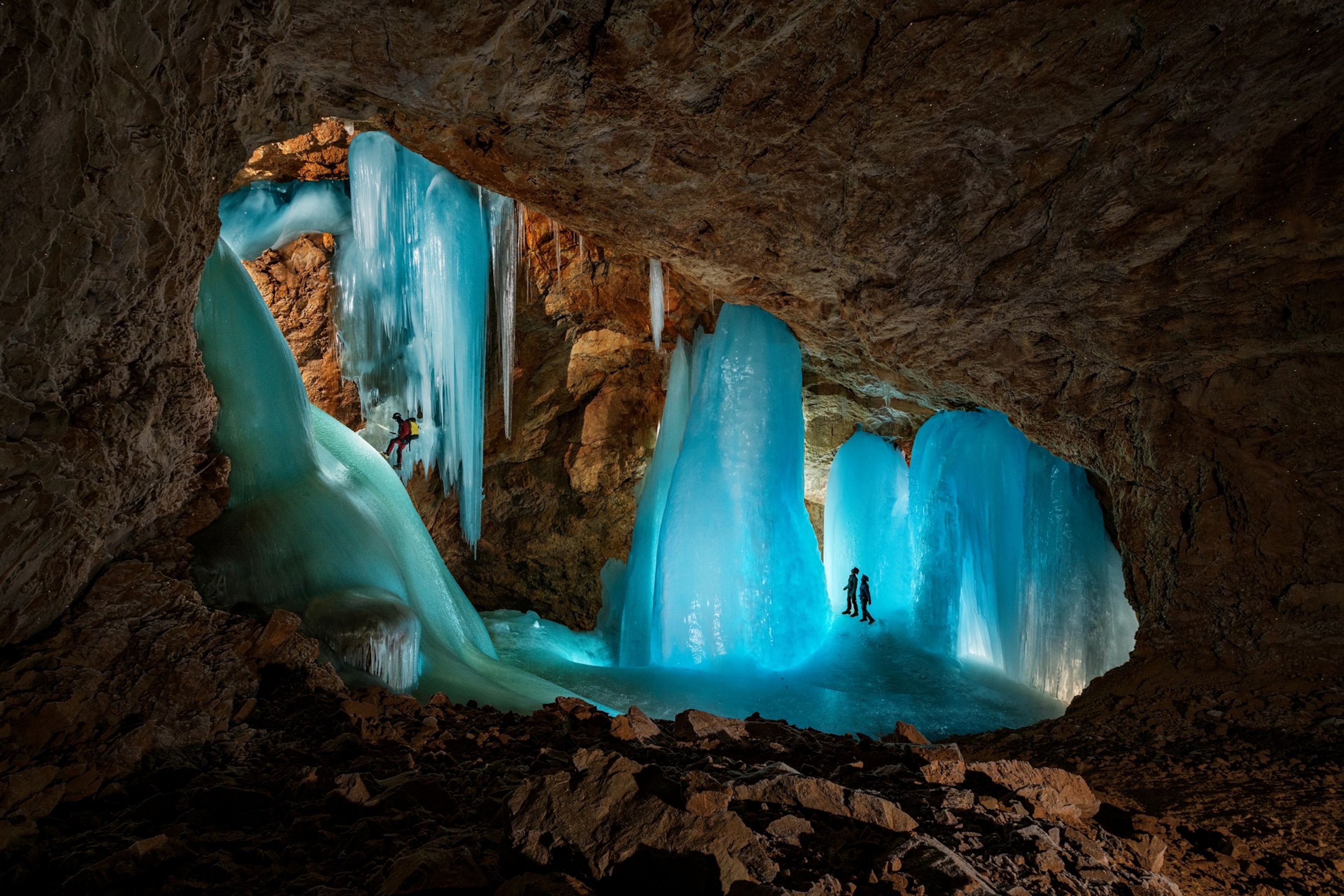 Picture of people in the rock cave with frozen waterfalls.