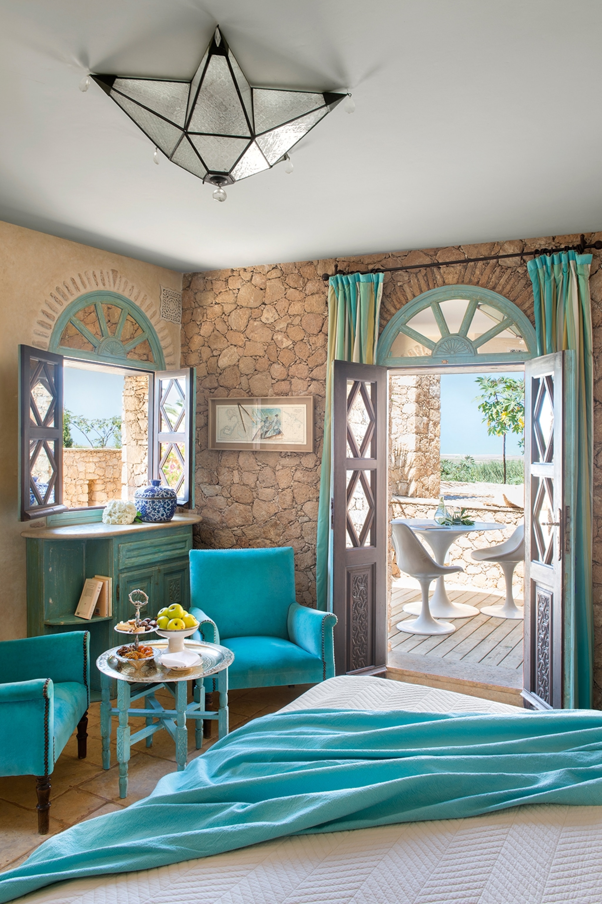 Interior of a stone-walled hotel room with turquoise blue touches