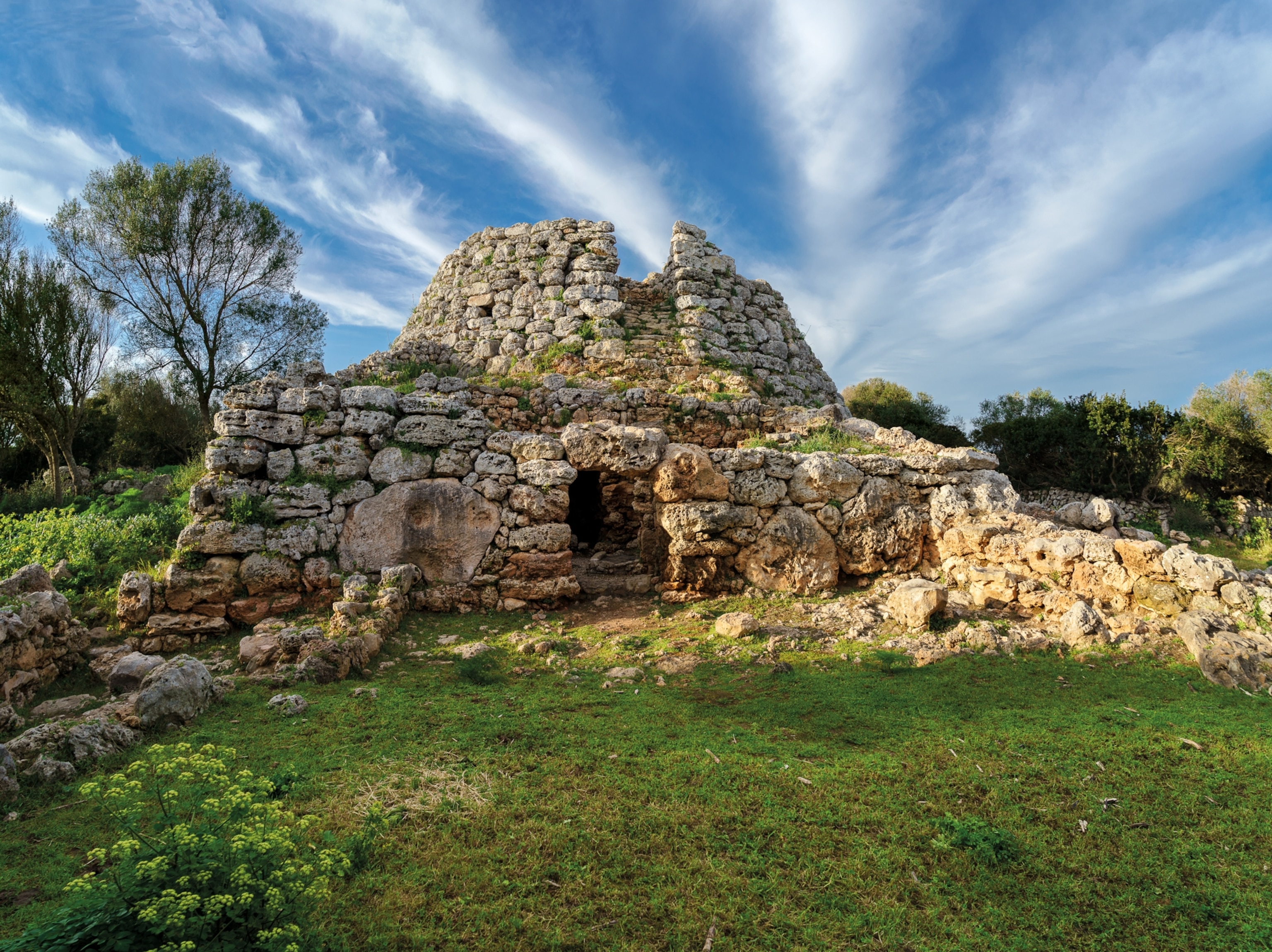 Stones piled on top of one another to for a building with an opening in the front