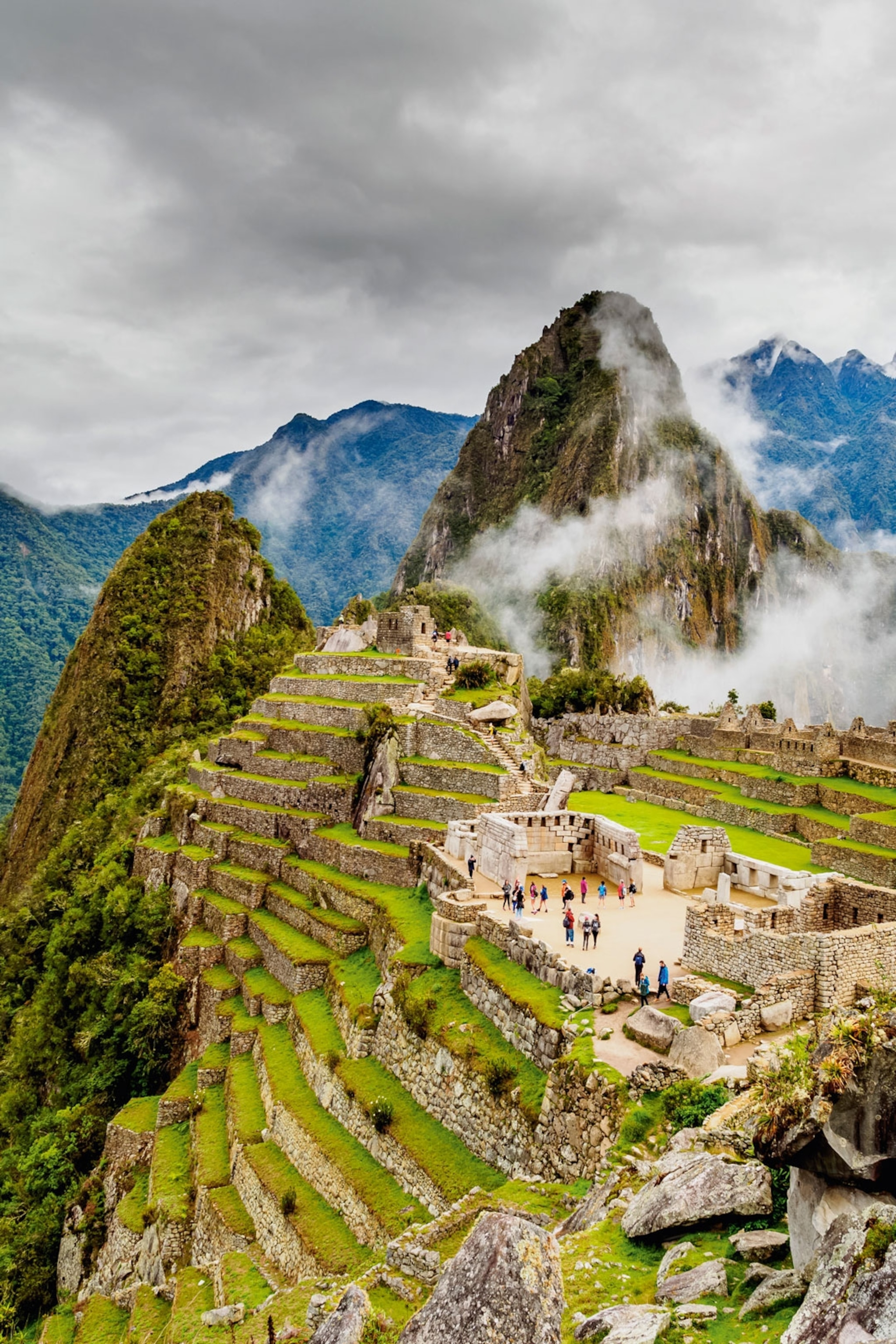 Historic ruins surrounded by clouds and mountains.