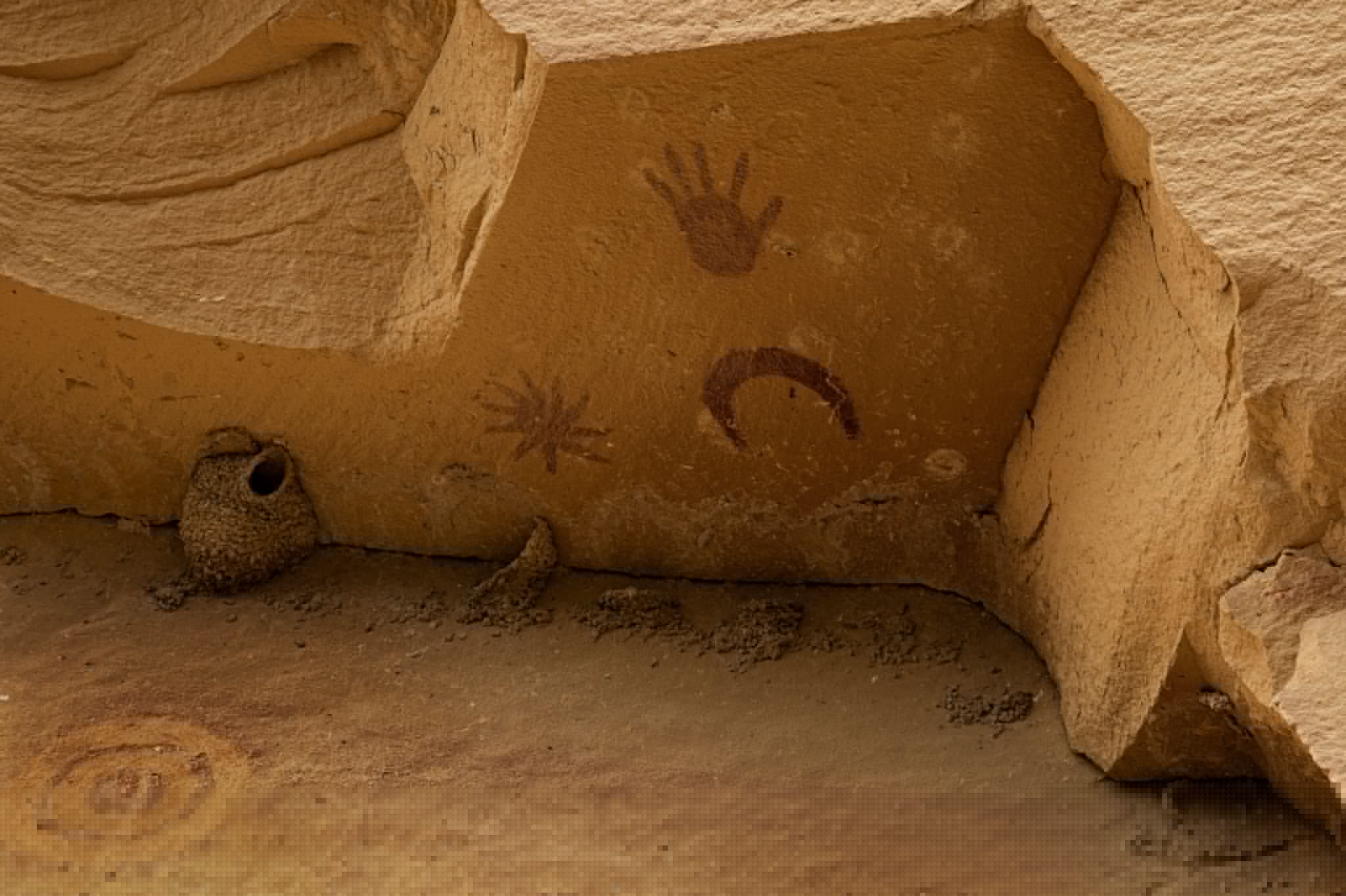Ancient pictograph of a hand, star, and moon.