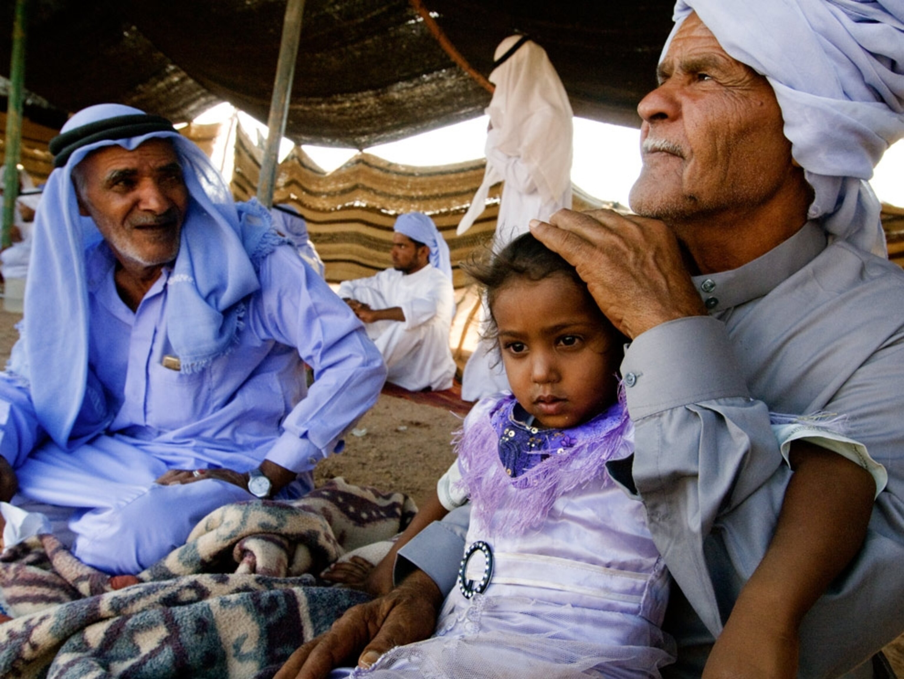 Two Bedouin men and child in a tent