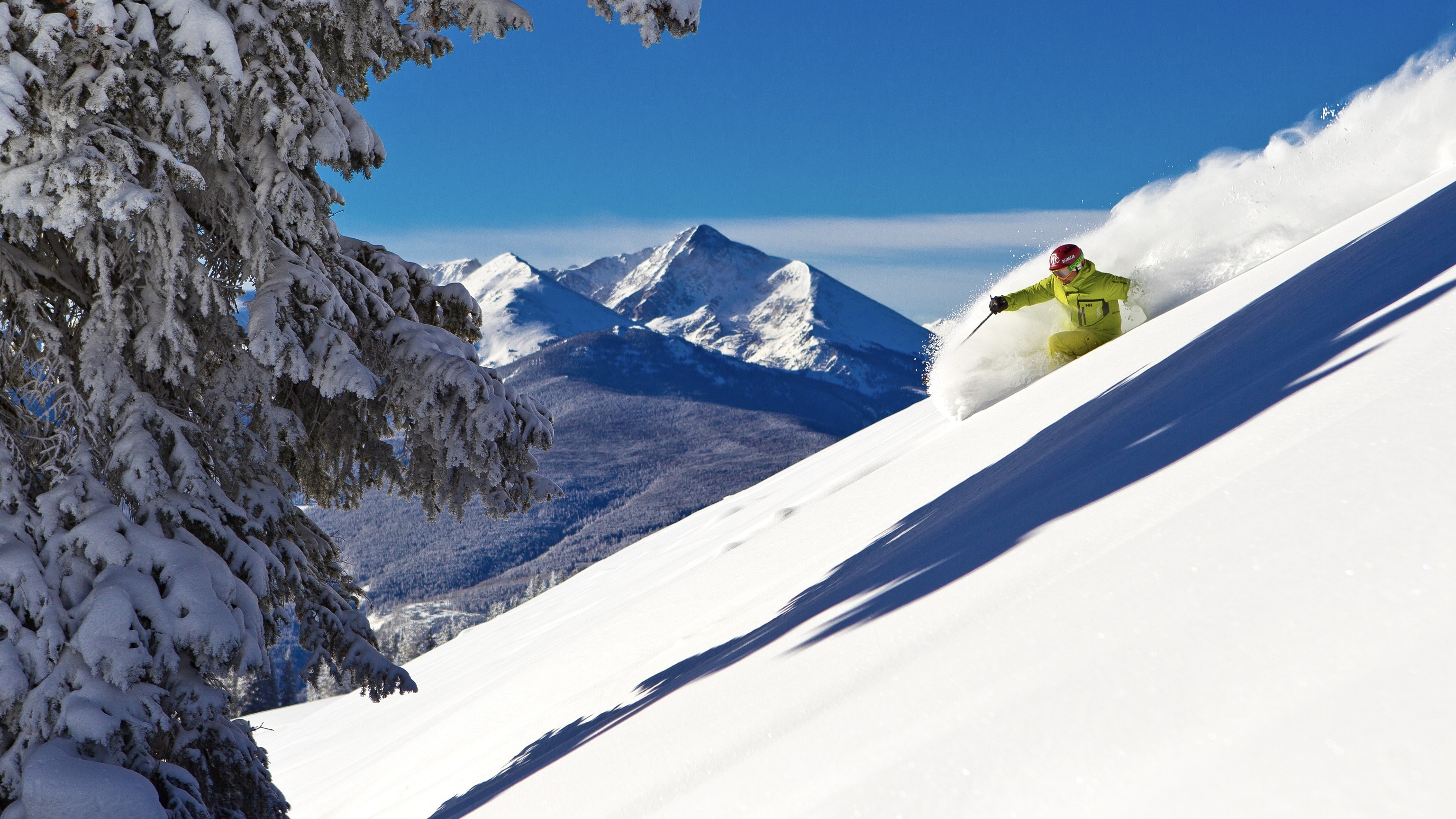 A skier in speeds down a snowy mountainside at Vail Resorts, Colorado