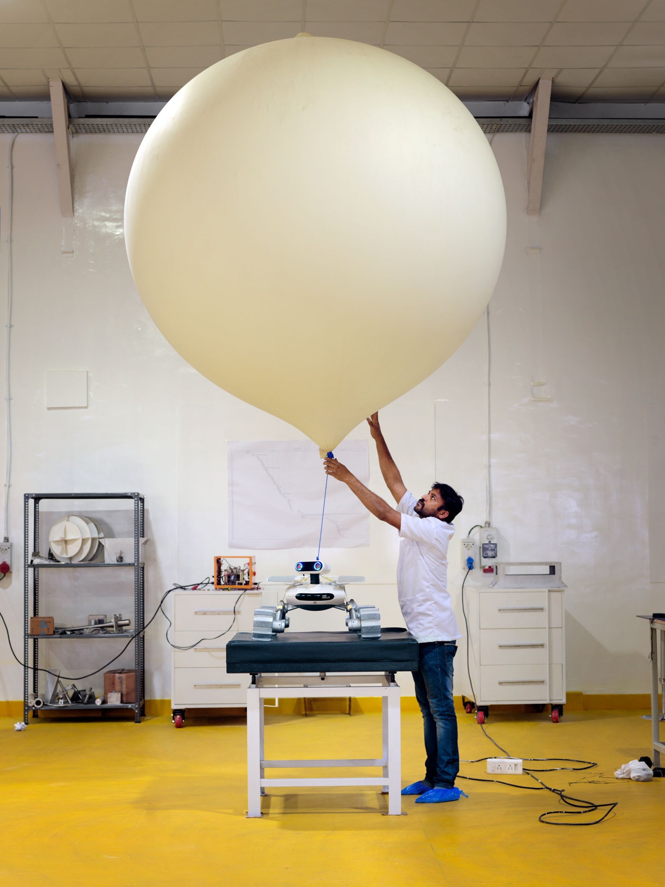 a man fixing a giant balloon tethered to a rover