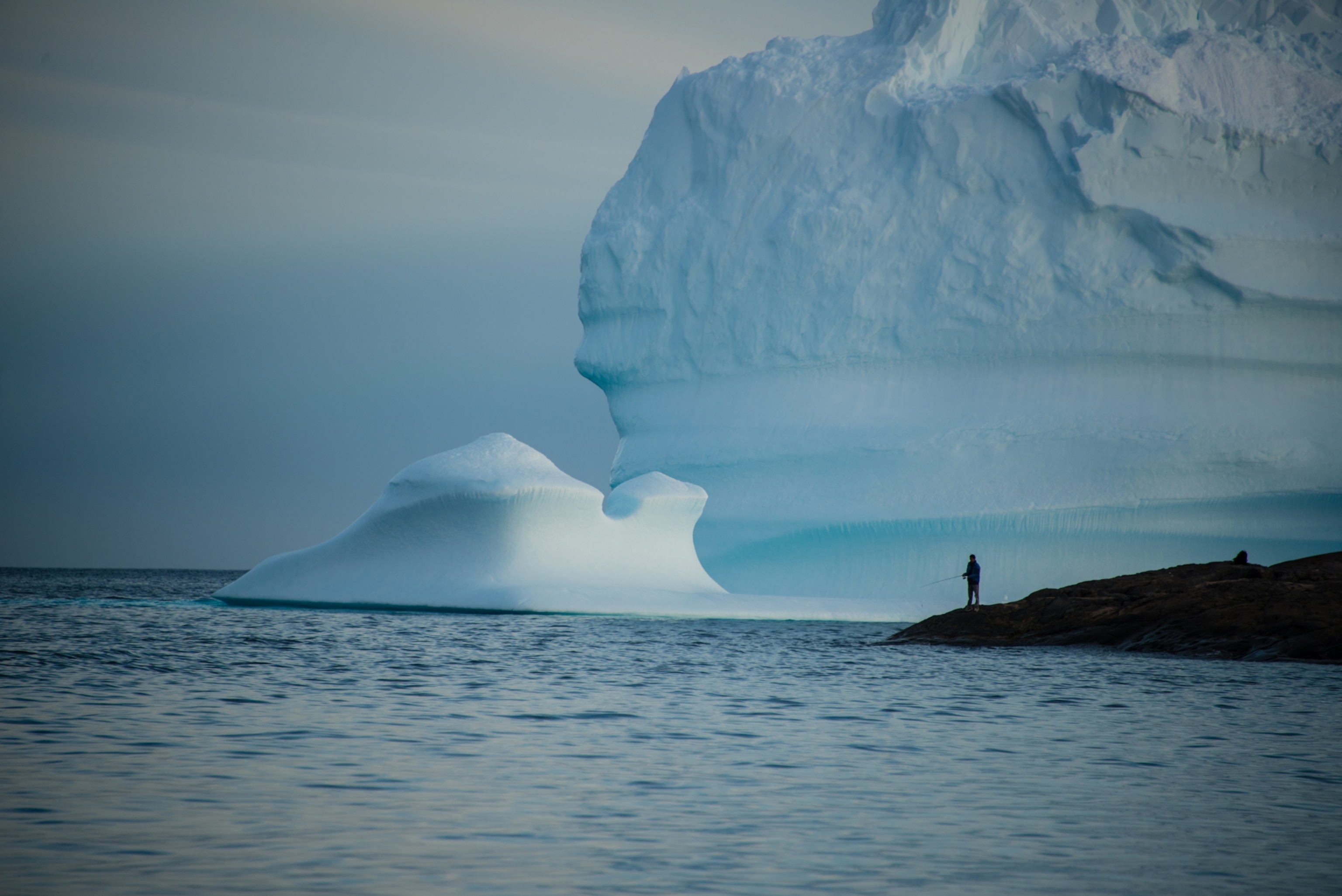 a person fishing on the shore of southeastern Greenland