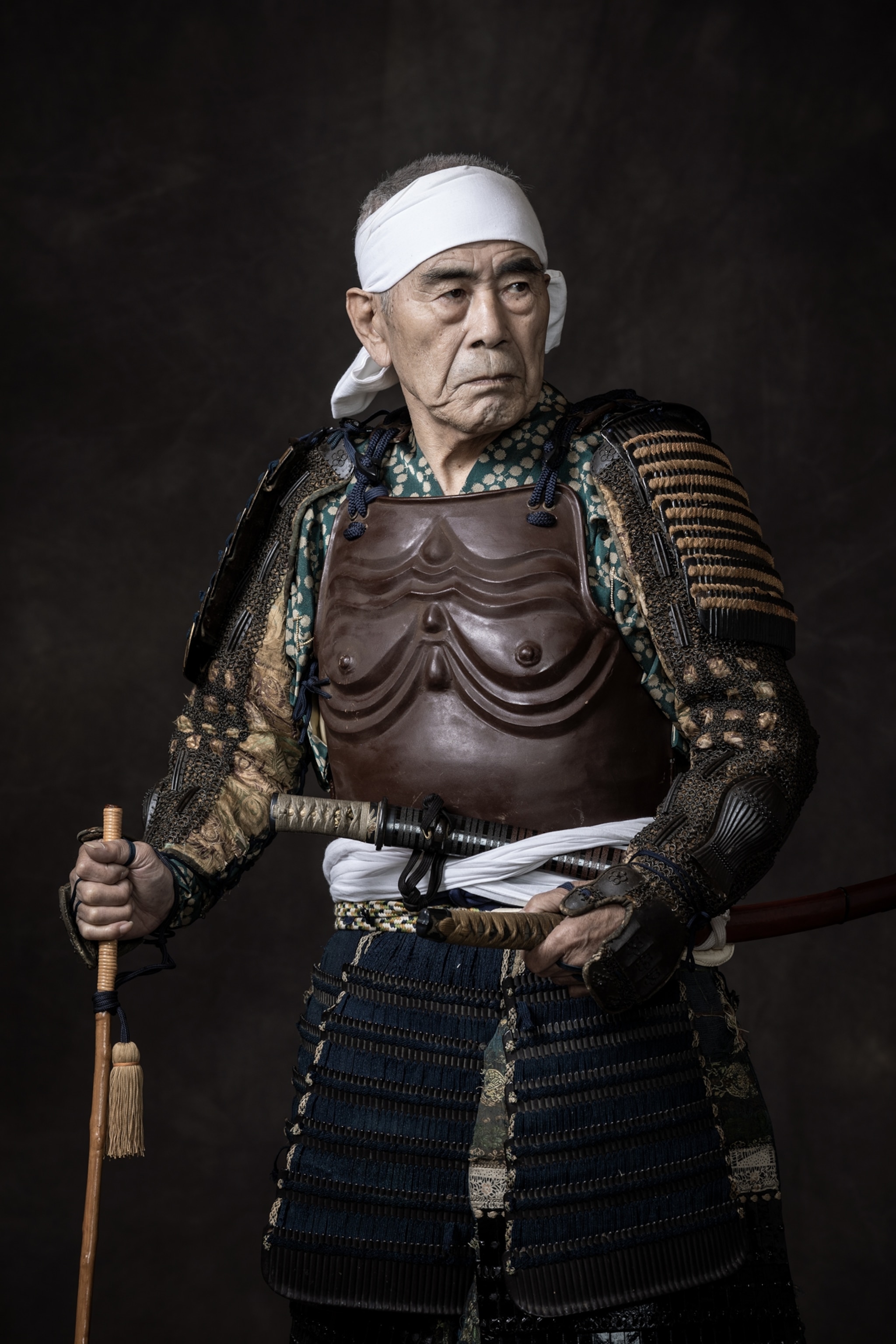 Picture of older man in body armor with white headband.