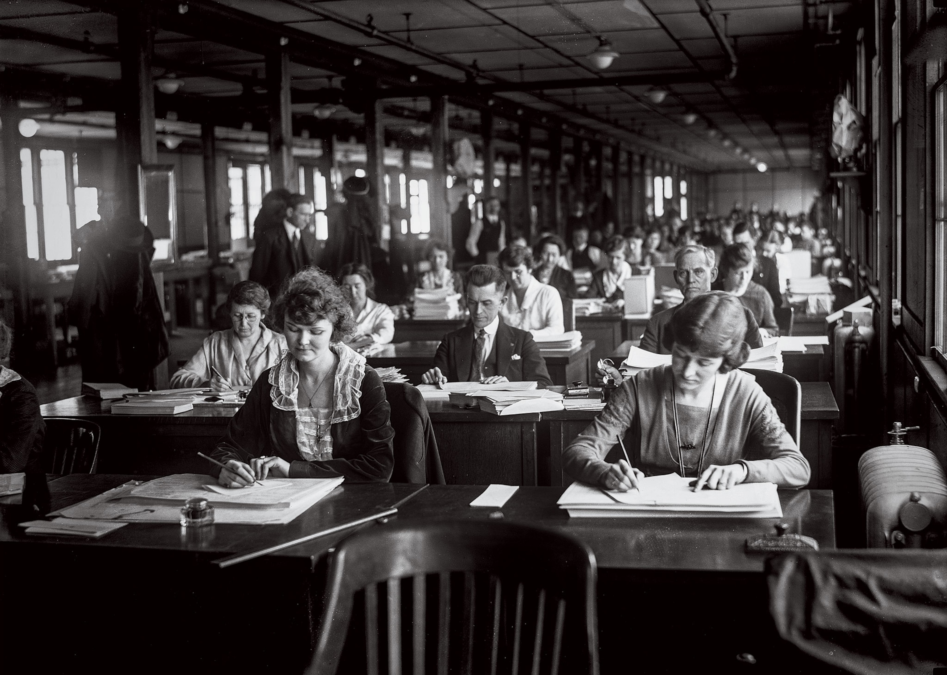 Clerks are seated in rows of desks in a black-and-white photo of a DC office