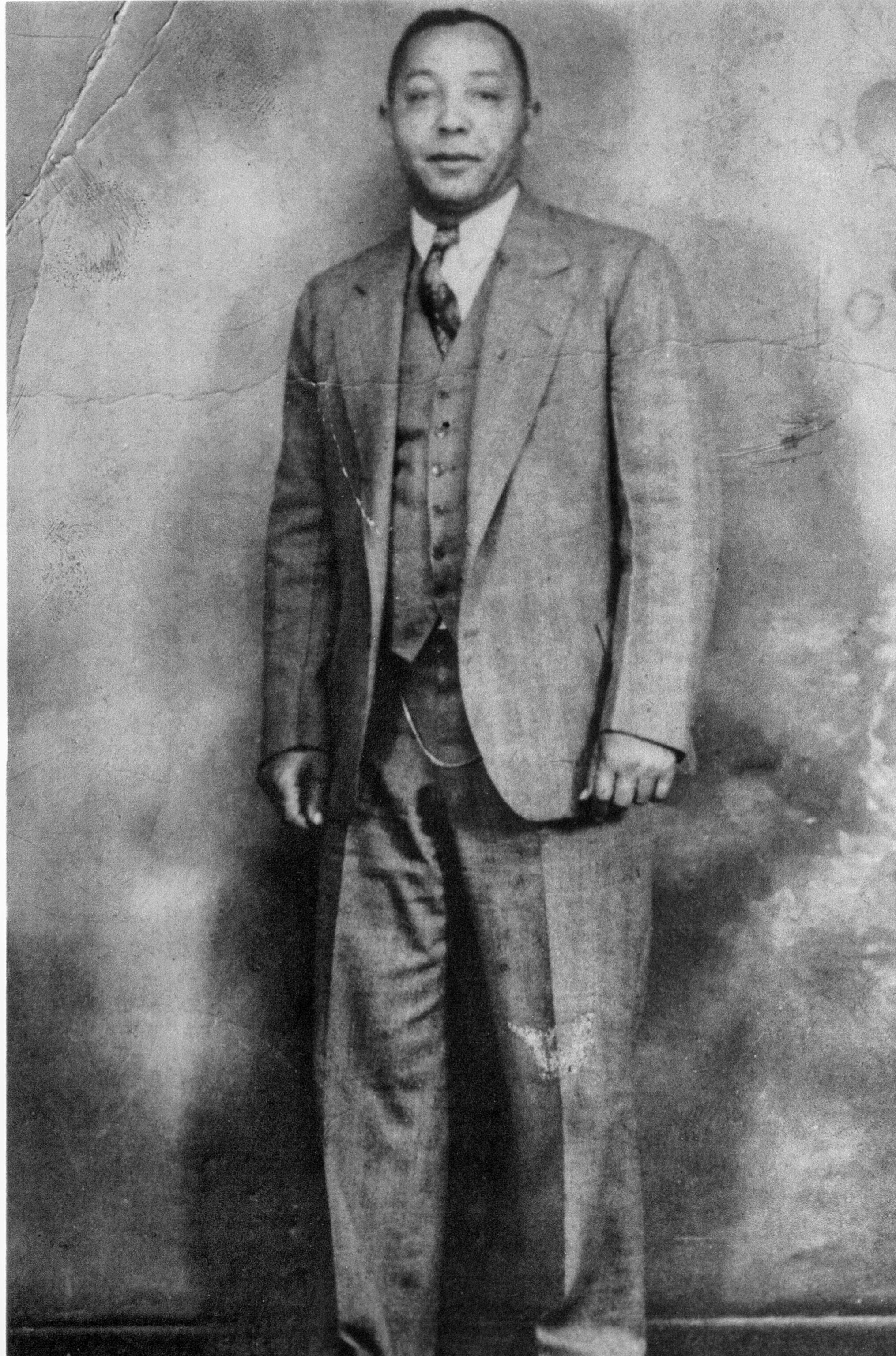 Black and white picture of a man standing in a suit